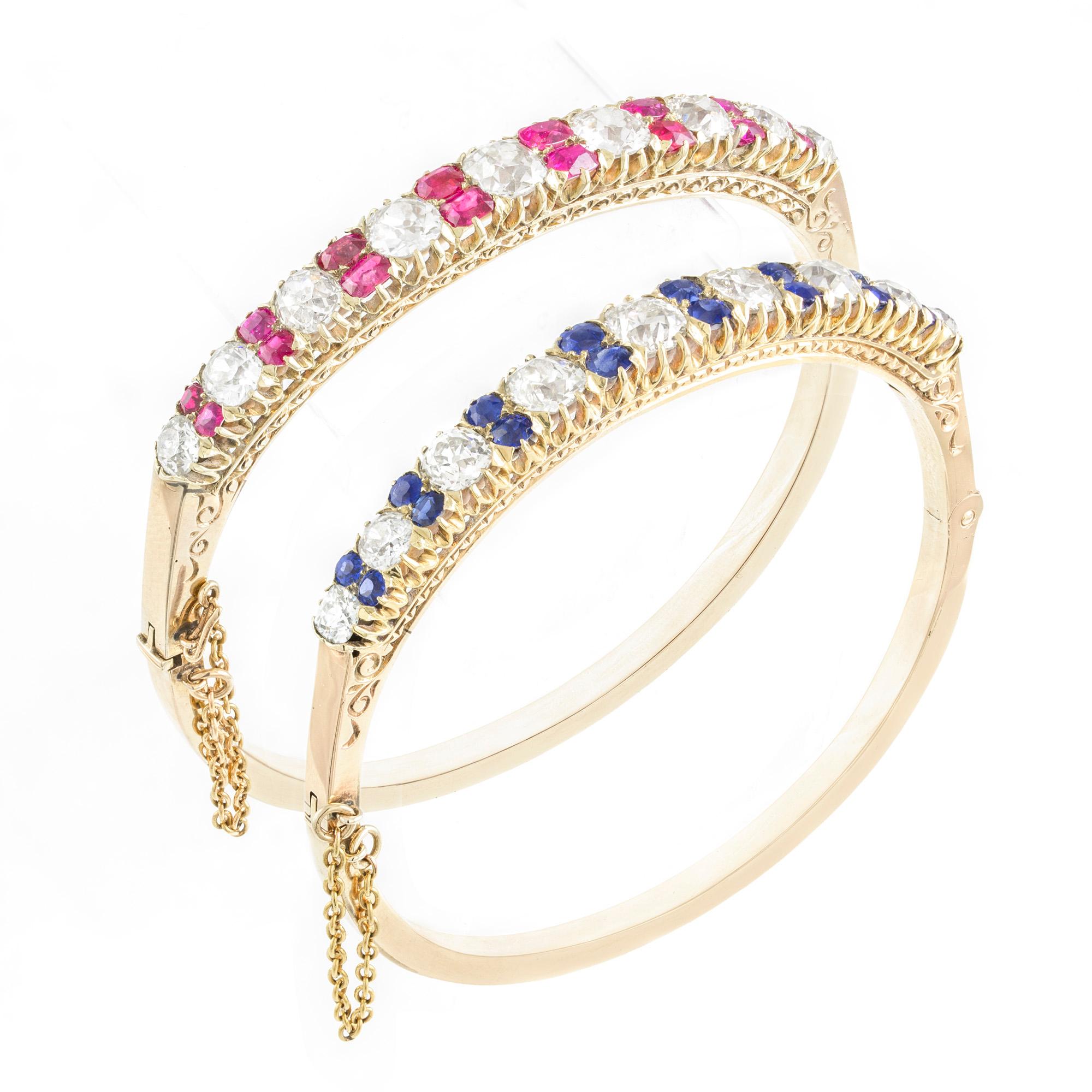 A pair of Victorian gem-set bangles, the upper sections each composed of graduating old brilliant-cut diamonds and respectively twin ruby and sapphire  spacers, the estimated total diamond content 10 carats, the eight pairs of graduating oval