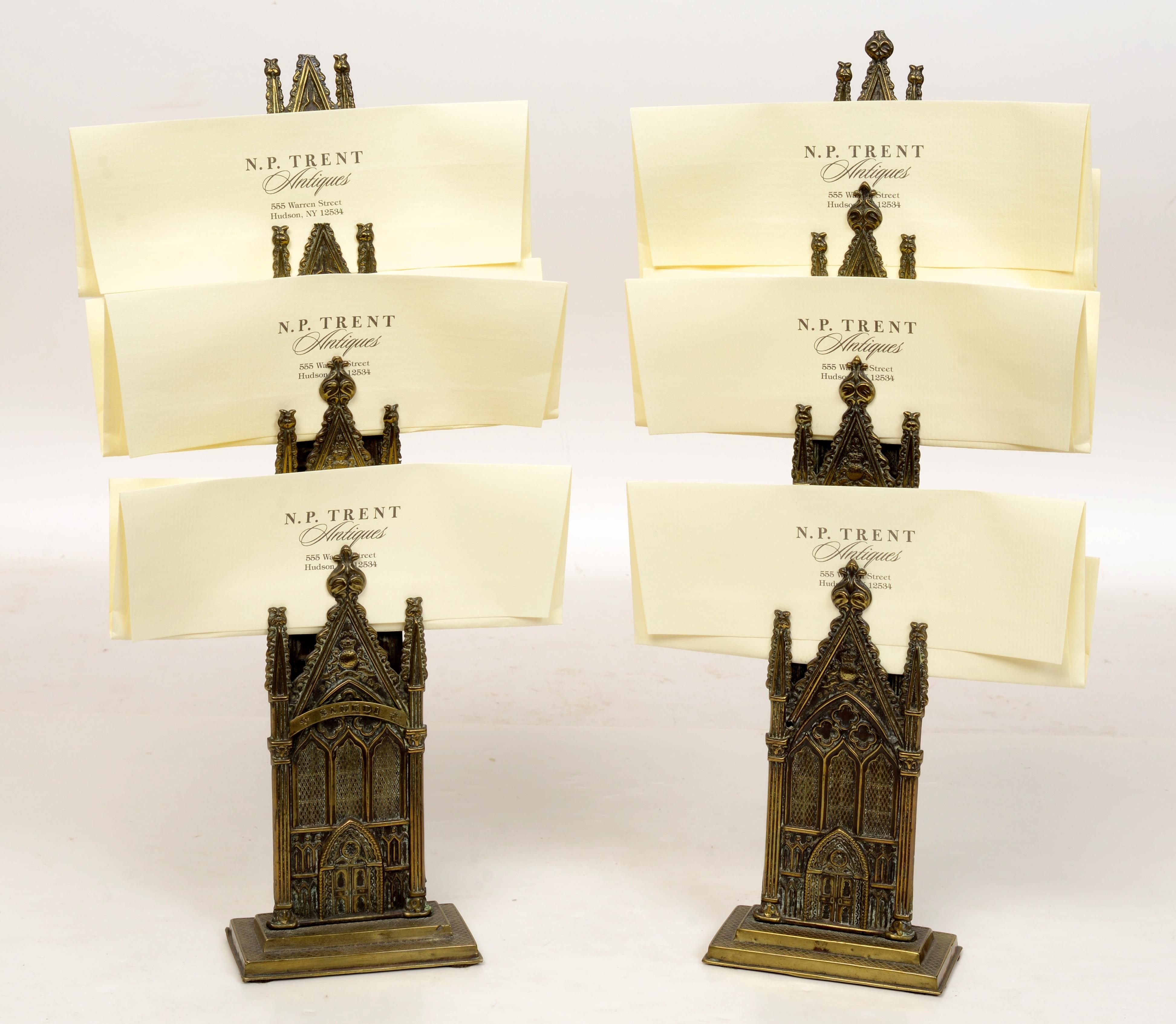 A pair of Victorian Gothic revival pressed brass letter Racks, 19th c. B. Days Patent, with the Royal Coat of Arms, both in the form of a Gothic multi-spired cathedral, each spire labeled with a day of the week in French, on a stepped plinth. One