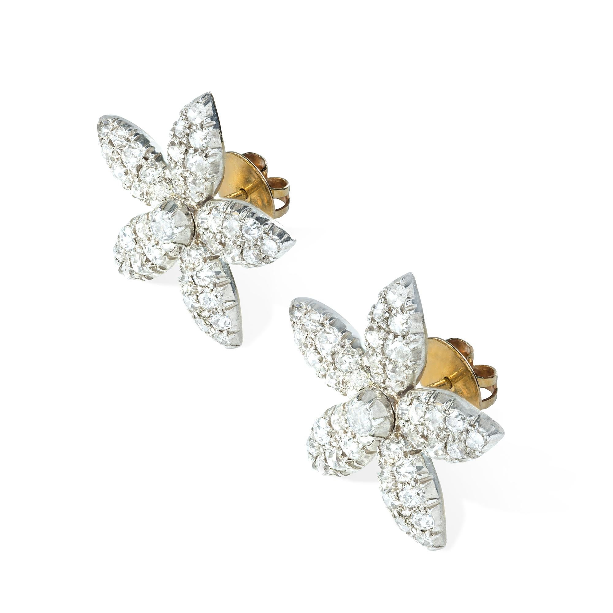 A pair of Victorian jasmine diamond earrings, each in the design of a five-petalled diamond encrusted jasmine head with a central old brilliant-cut diamond, the diamonds estimated to weigh a total of approximately 5 carats, all cut-down set in