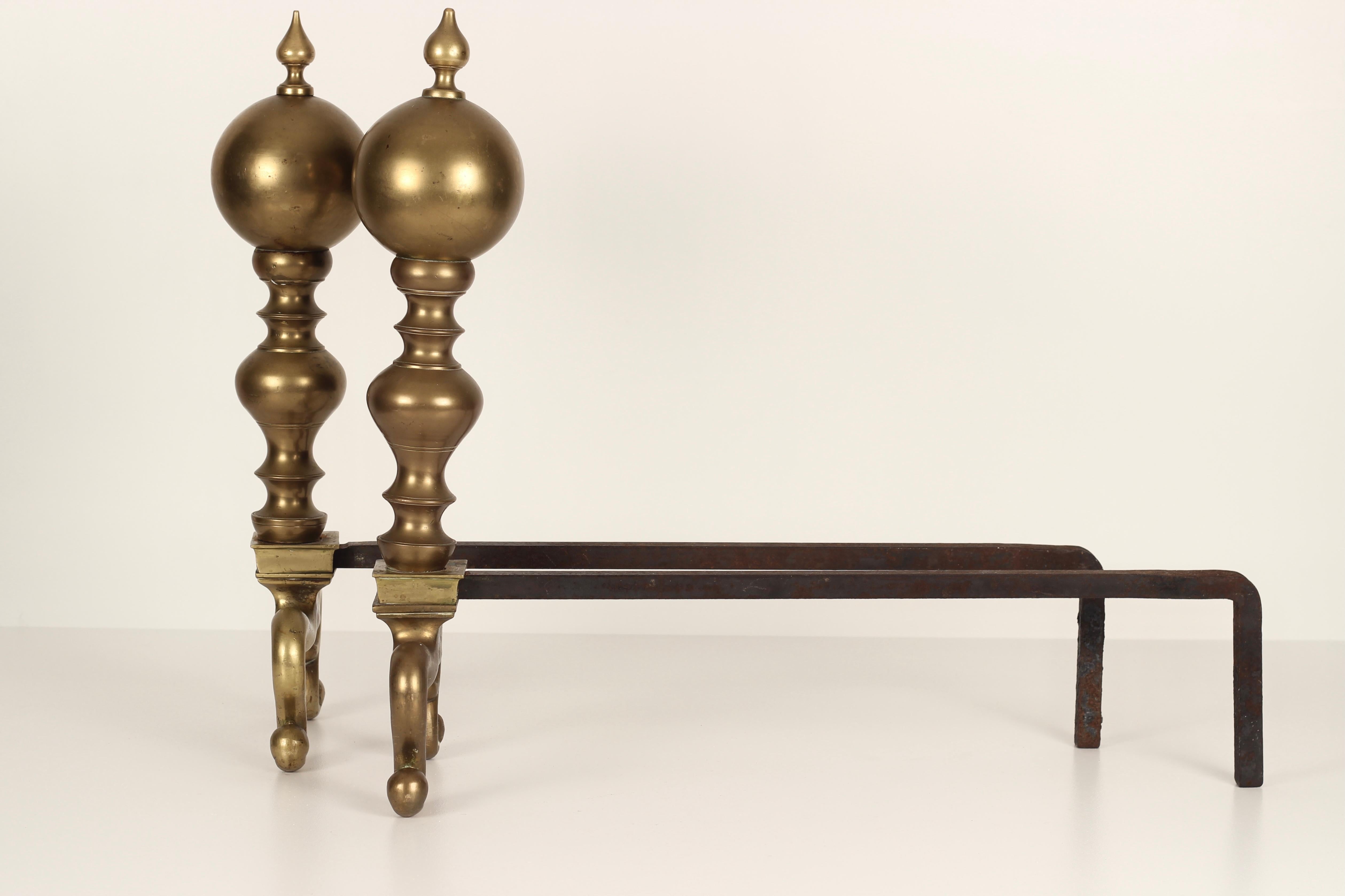 A pair of Victorian late 19th century, early 20th century brass fire irons or Andirons, possibly produced around the time of the Aesthetic Movement with influences from Persia. 

Andirons and fire dogs are devices made of metal and (rarely)