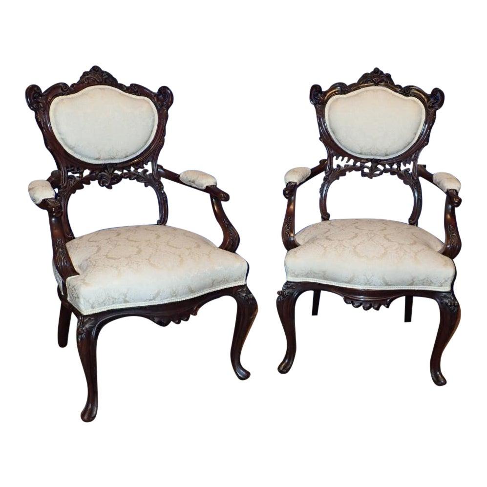 A pair of Victorian Rococo Carved Arm Chairs