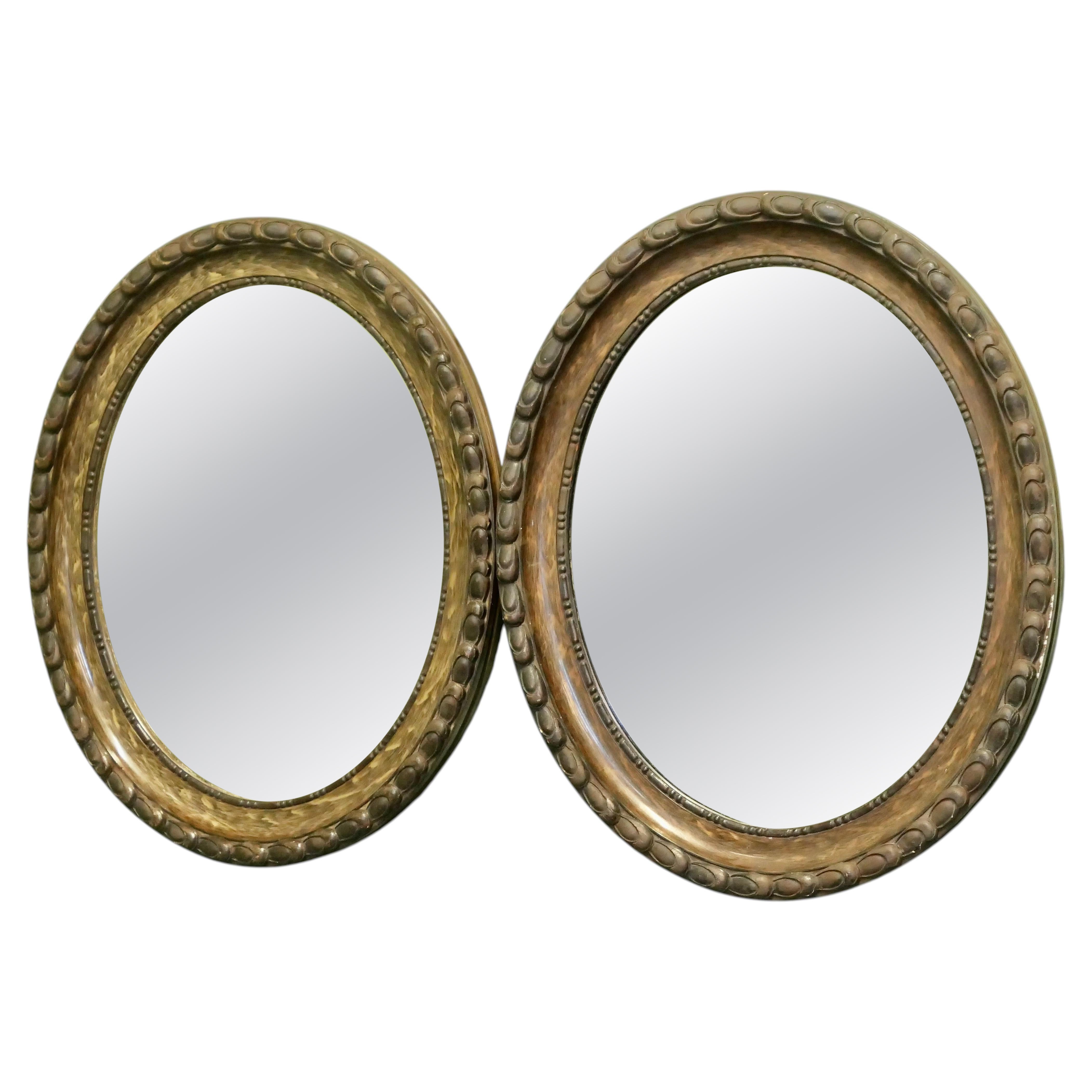 A pair of Victorian Simulated Wood Finish Oval Mirrors For Sale