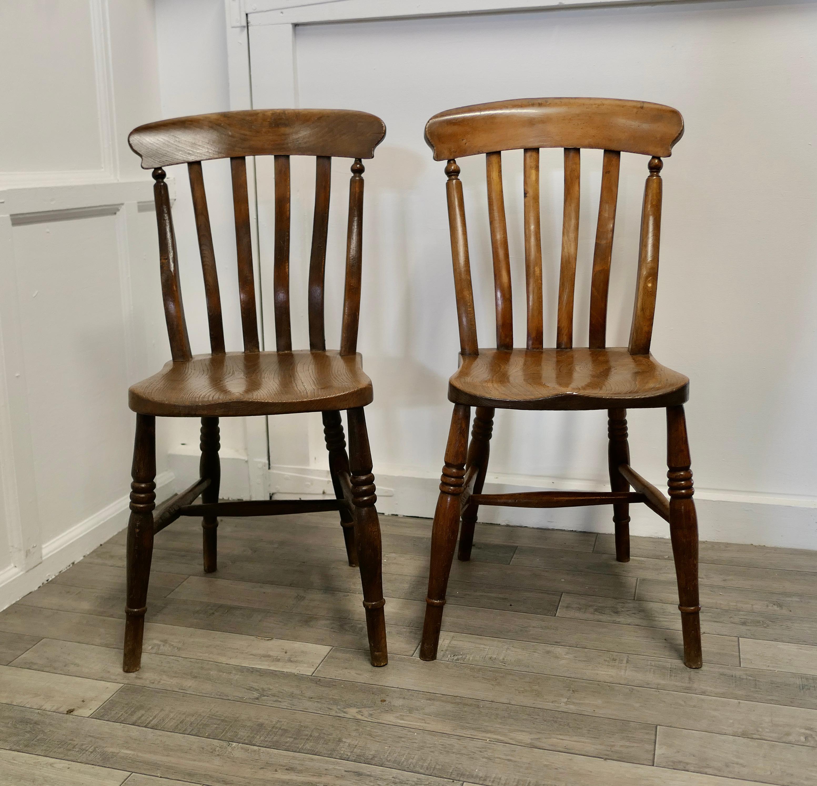 A pair of Victorian slat back farmhouse kitchen chairs

A good sturdy pair of Victorian slat back kitchen dining chairs
The chairs have solid elm seats and turned beech legs and stretchers 
This very attractive pair comes in their original wax