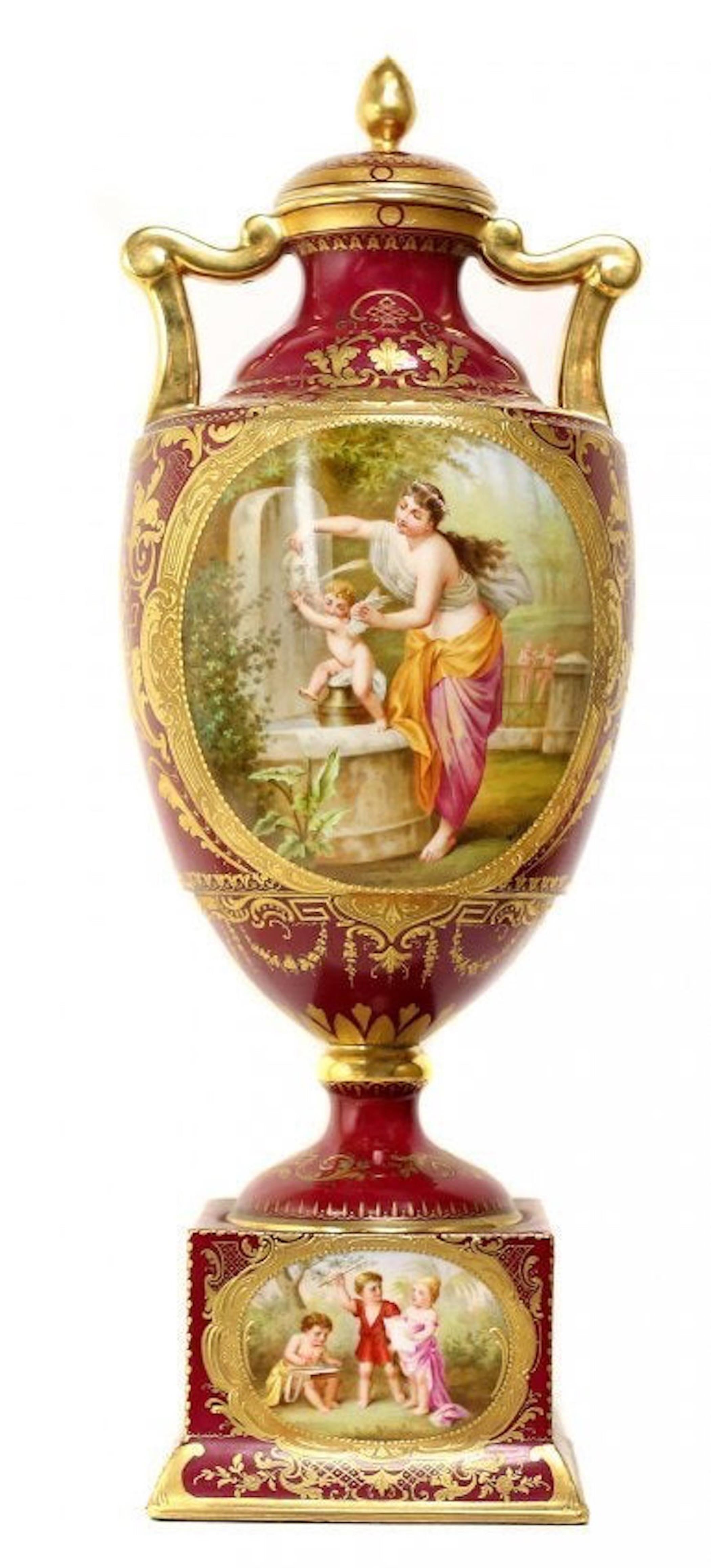 A pair of Vienna style covered urns, late 19th century.
Each finely painted with a maiden and a putto. 
Measures: Height 18.5 in. (46.99 cm.); Width 7 in. (17.78 cm.); Depth 7 in. 17.78 cm.)
 