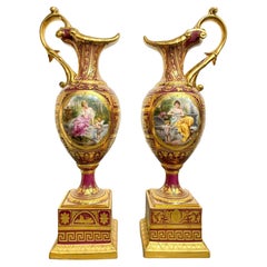 A Pair of Vienna Style Porcelain Iridescent Burgundy Ground Ewers on Stands 