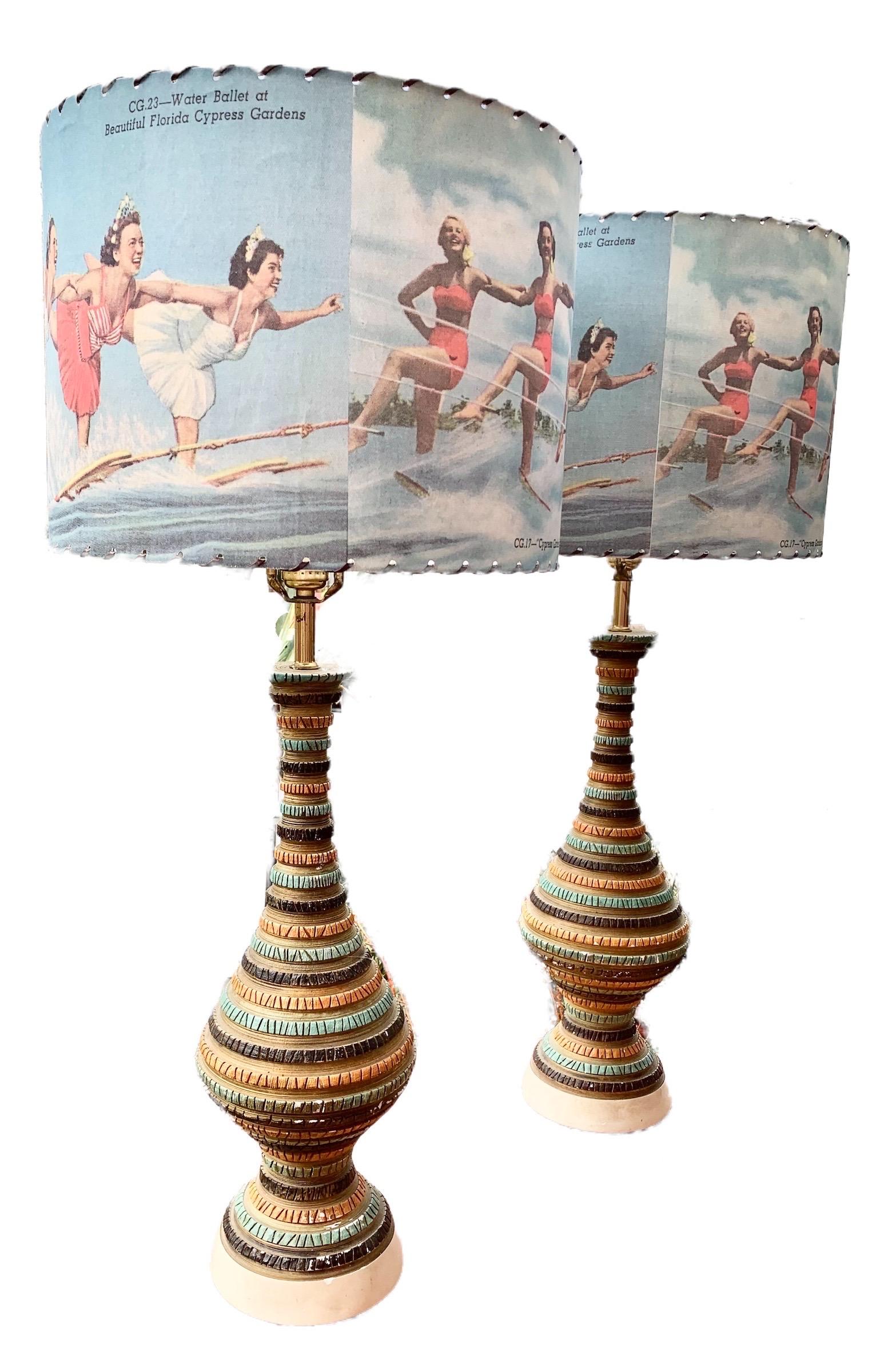 A stunning pair of Mid-Century Modern chalk ware or plaster table lamps with whip stitched drum shades depicting 
