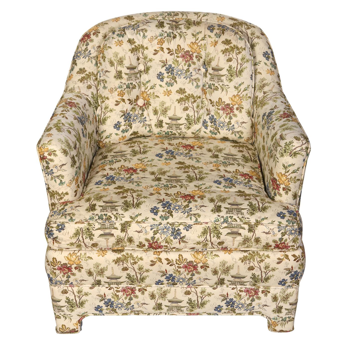 A pair of vintage upholstered club chairs with great lines and proportion.  The chairs, covered in a floral with a Chinoiserie motif, feature loose seat and back cushions, sloped arms and chic upholstered legs.  Their compact shape and size make