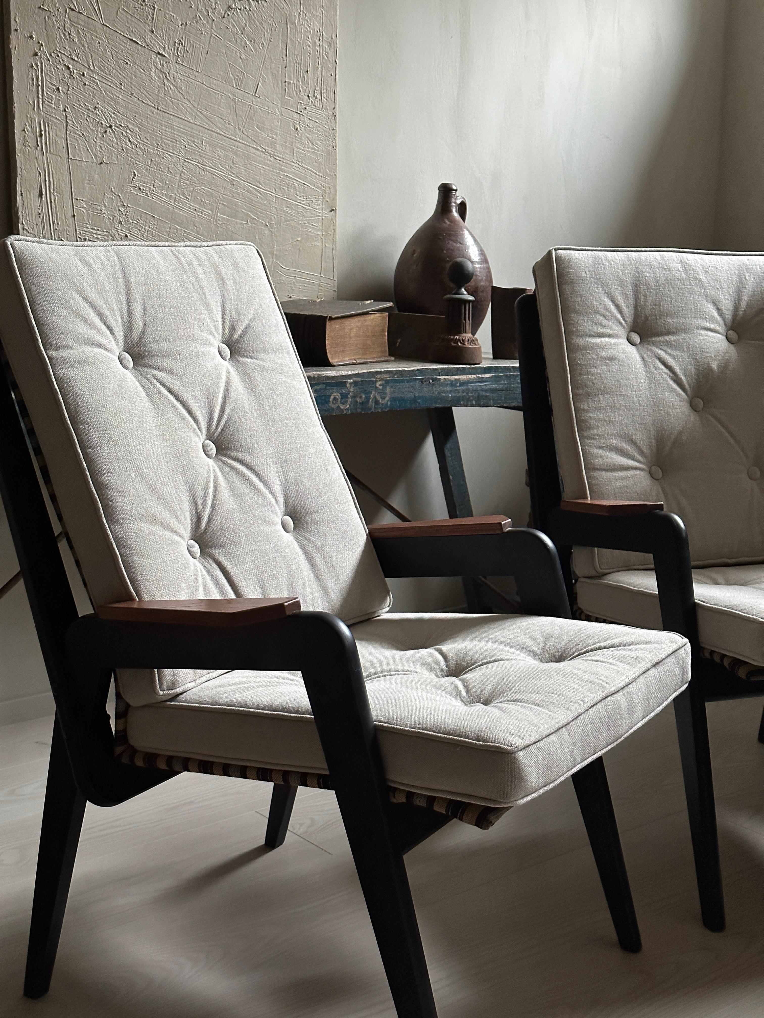 A pair of armchair by unknown designer from 1960s, in style of Jean Prouvé. Arms and legs of dark stained wood with new linen cushions. 

A simple and fuctional design made comfortable with new cushions. 

