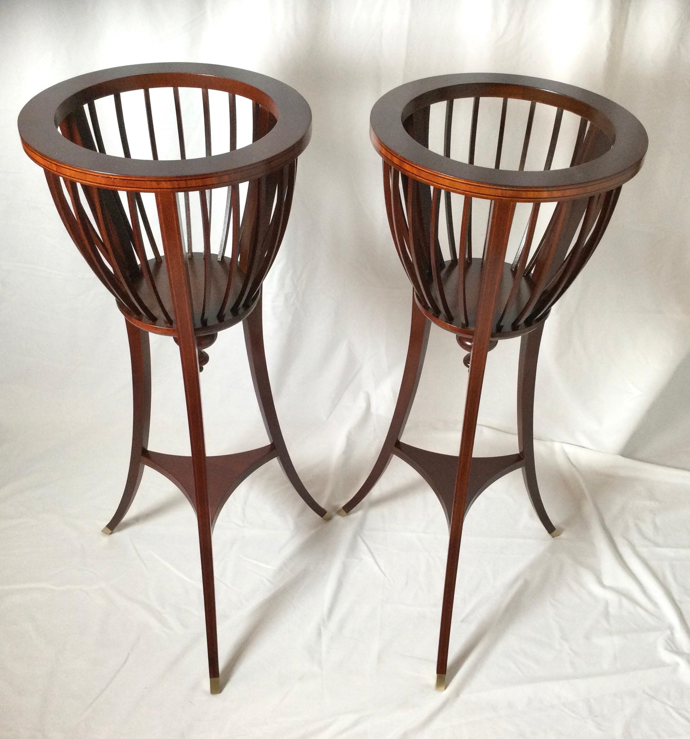 Elegant pair of Baker Charleston collection plant stands the upper spoked pant holders with graceful splayed legs with brass capped feet. The top rim and legs with a subtle pencil inlay.