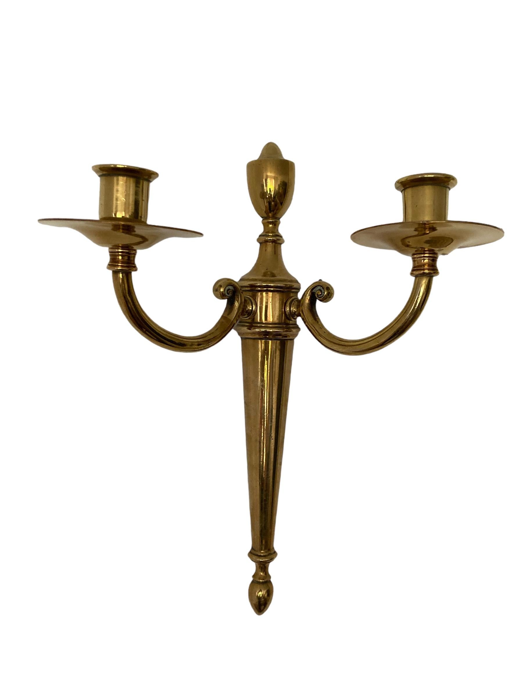 A Pair of Vintage Brass Candle Holder Wall Sconces. Enhance the ambiance of your living space with these elegant brass candlestick Holders. Featuring ywo arms each. Crafted with attention to detail, they exude a timeless charm that will complement