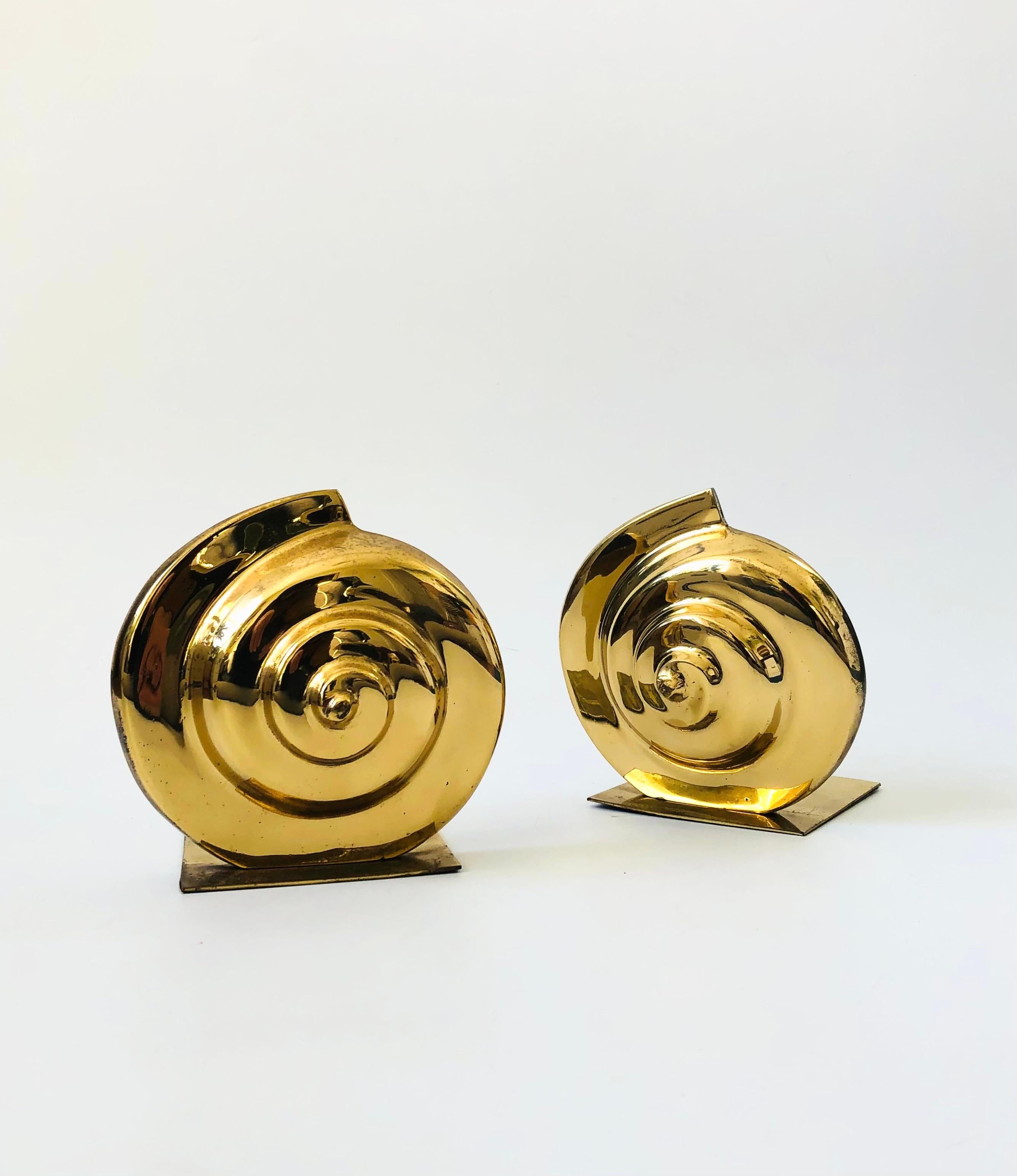 A pair of vintage brass bookends in the shape of nautilus shells. Great simplified deco shape with nice heavy weights. Felted bases.

