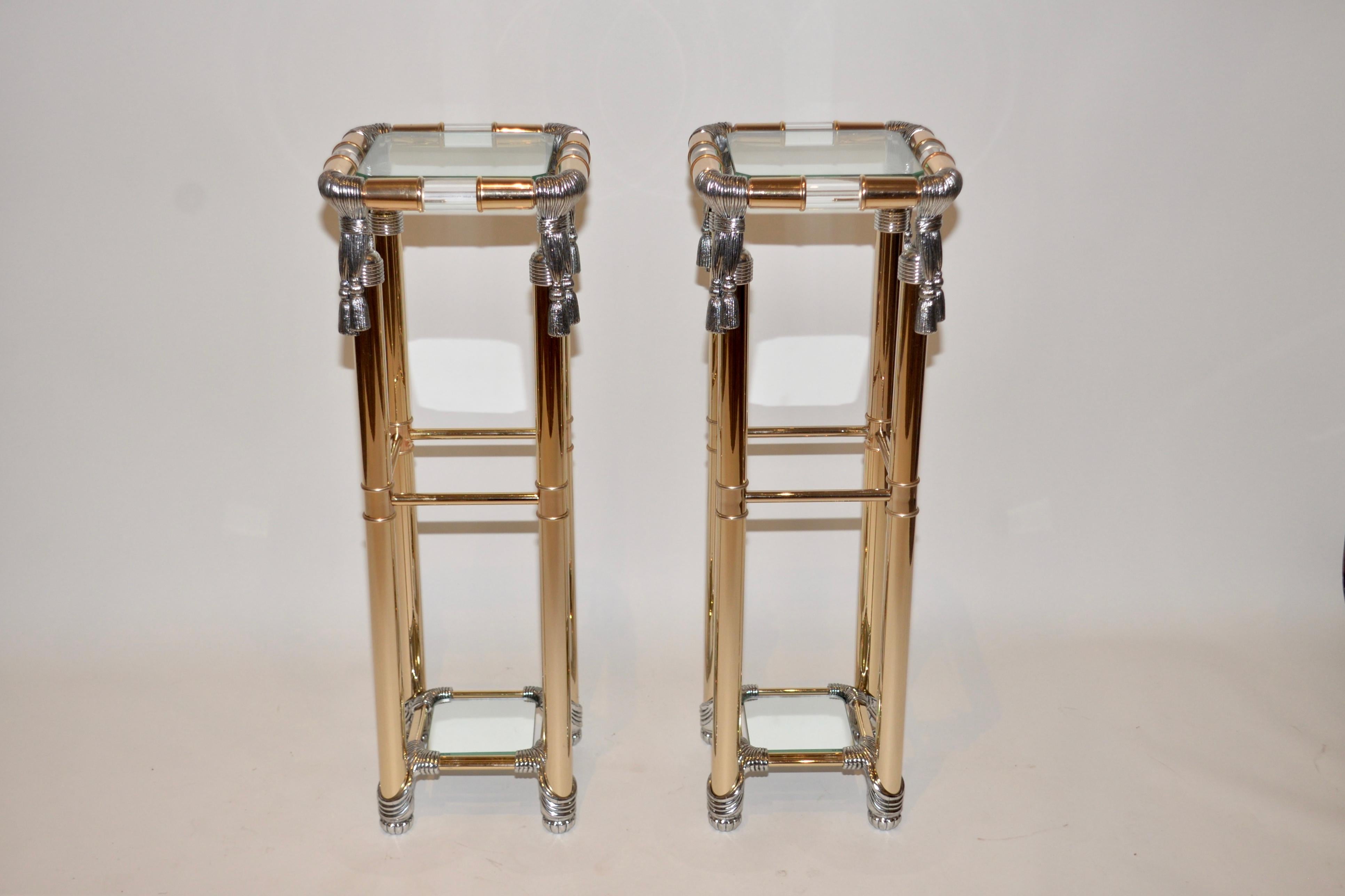 A pair of vintage Curvasa Meubles Hollywood Regency style pedestal stands. Lucite and gold with silver rope detailing on each corner. Very striking items.