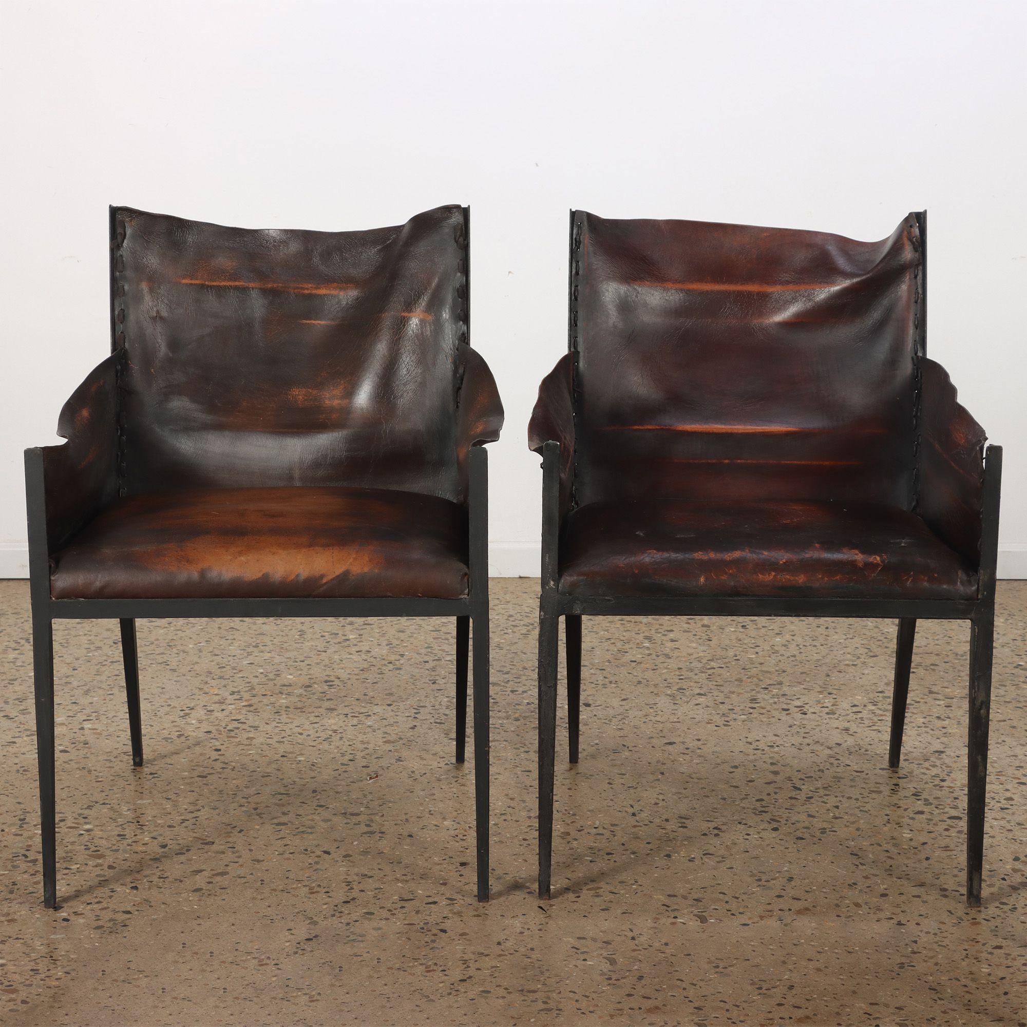 A pair of iron and leather armchairs in the manner of Jean-Michel Frank, contemporary.