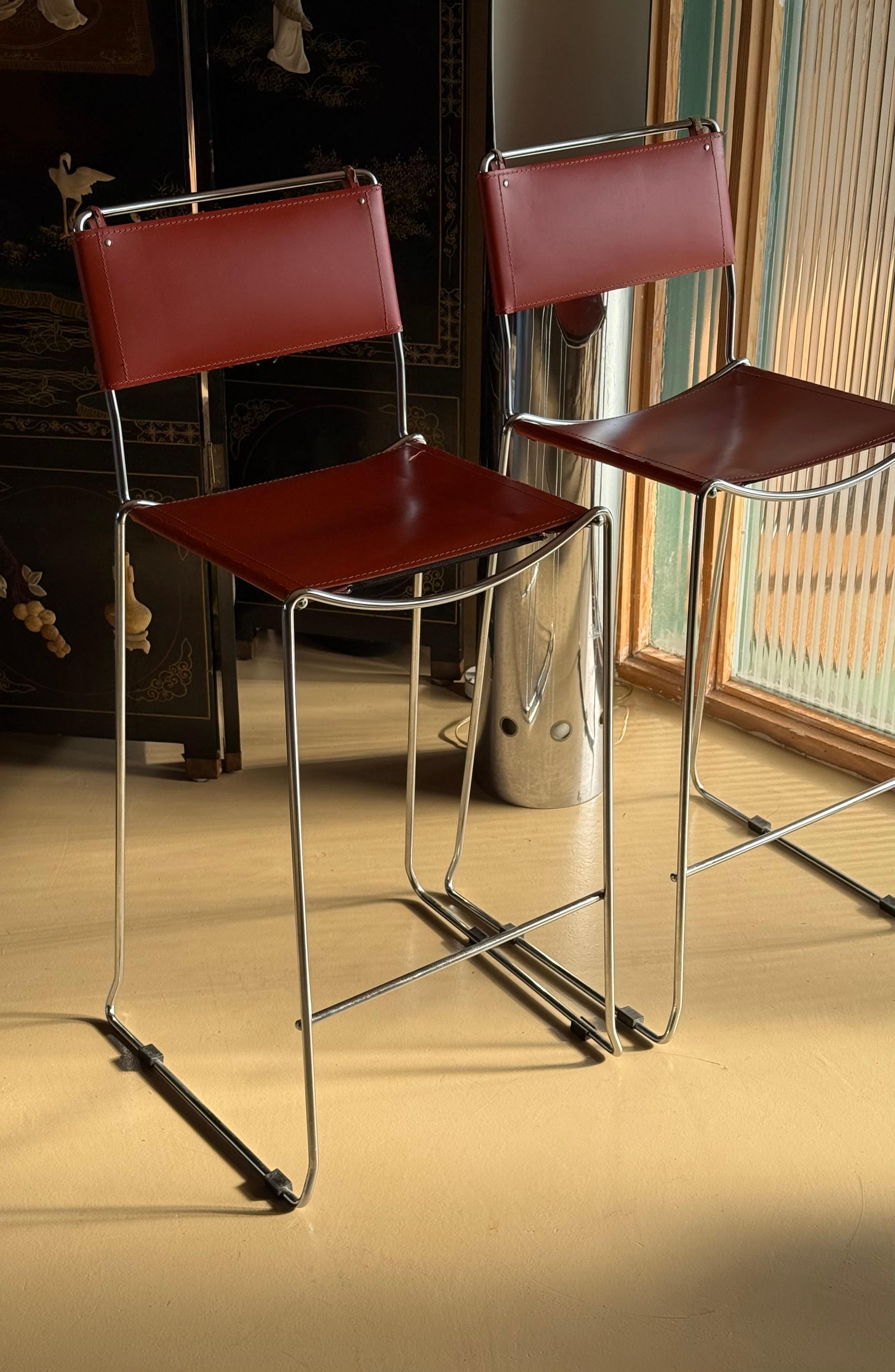Paire de tabourets de bar MCM en cuir orange, fabriqués en Italie au milieu du XXe siècle. Avec cuir kaki et surpiqûres crème. Chaque chaise porte la mention 