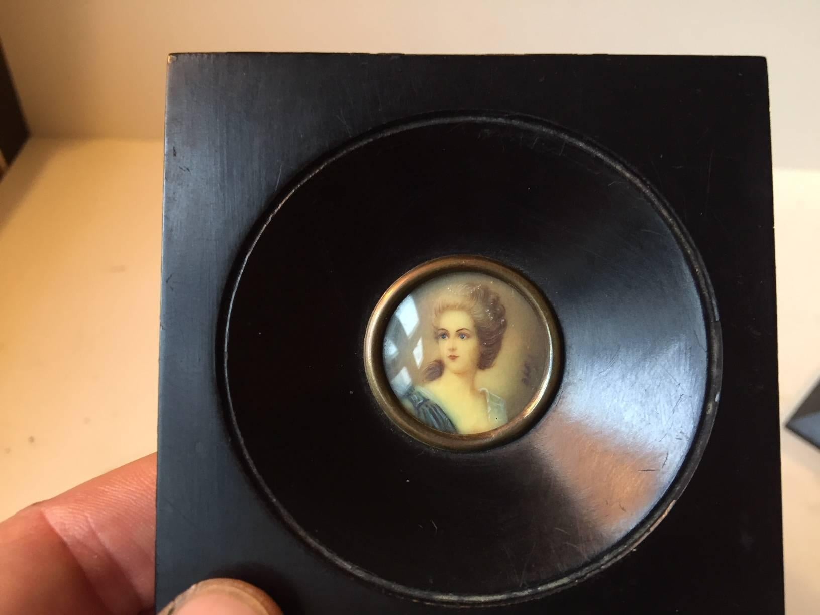 A pair of Italian miniature portraits with ebonized wooden frames. The portraits measures 1.2 inch in diameter. Purchased between 1940-1960 at Savarese Art Shop in Sorrento Italy. Both pieces are signed and the models names are present to the makers