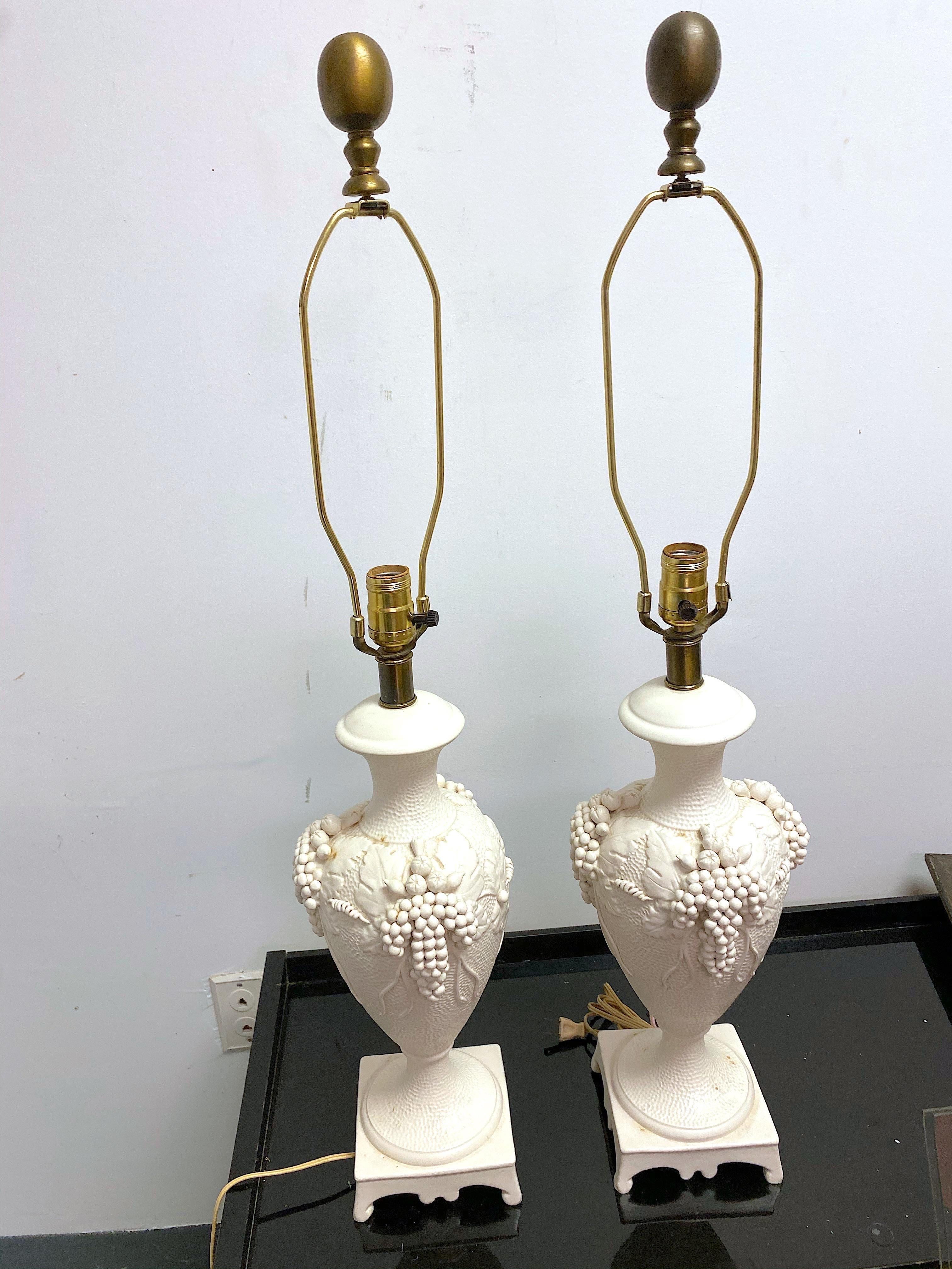 These lamps are just gorgeous! With an urn shape and a grape leaves relief. The body is highly textured and the base and neck are very smooth. They are signed “Greenspan” on the bottom as well as marked Italy. They have the original harps and gold