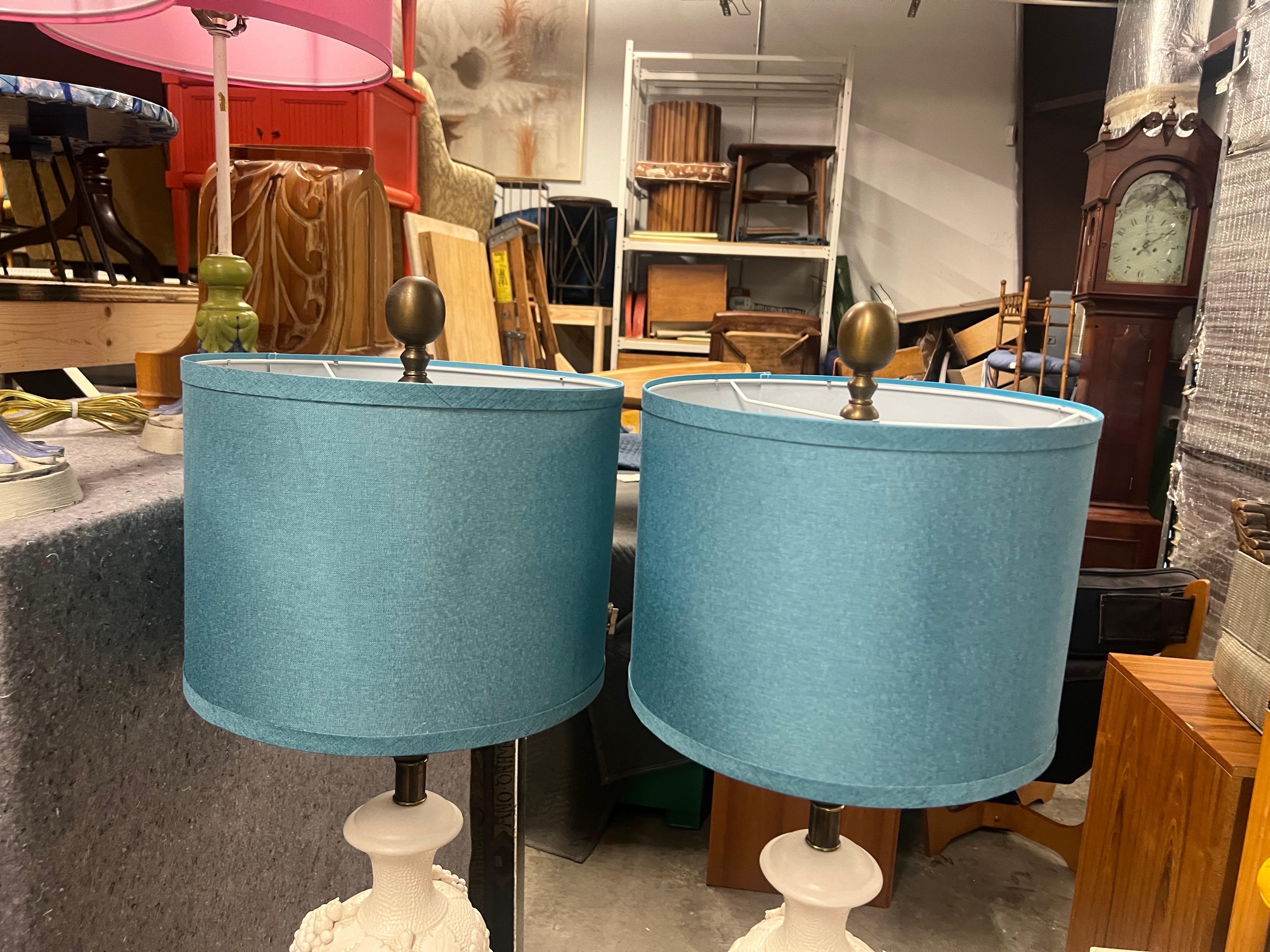 These lamps are just gorgeous! With an urn shape and a grape leaves relief. The body is highly textured and the base and neck are very smooth. They are signed “Greenspan” on the bottom as well as marked Italy. They have the original harps and gold