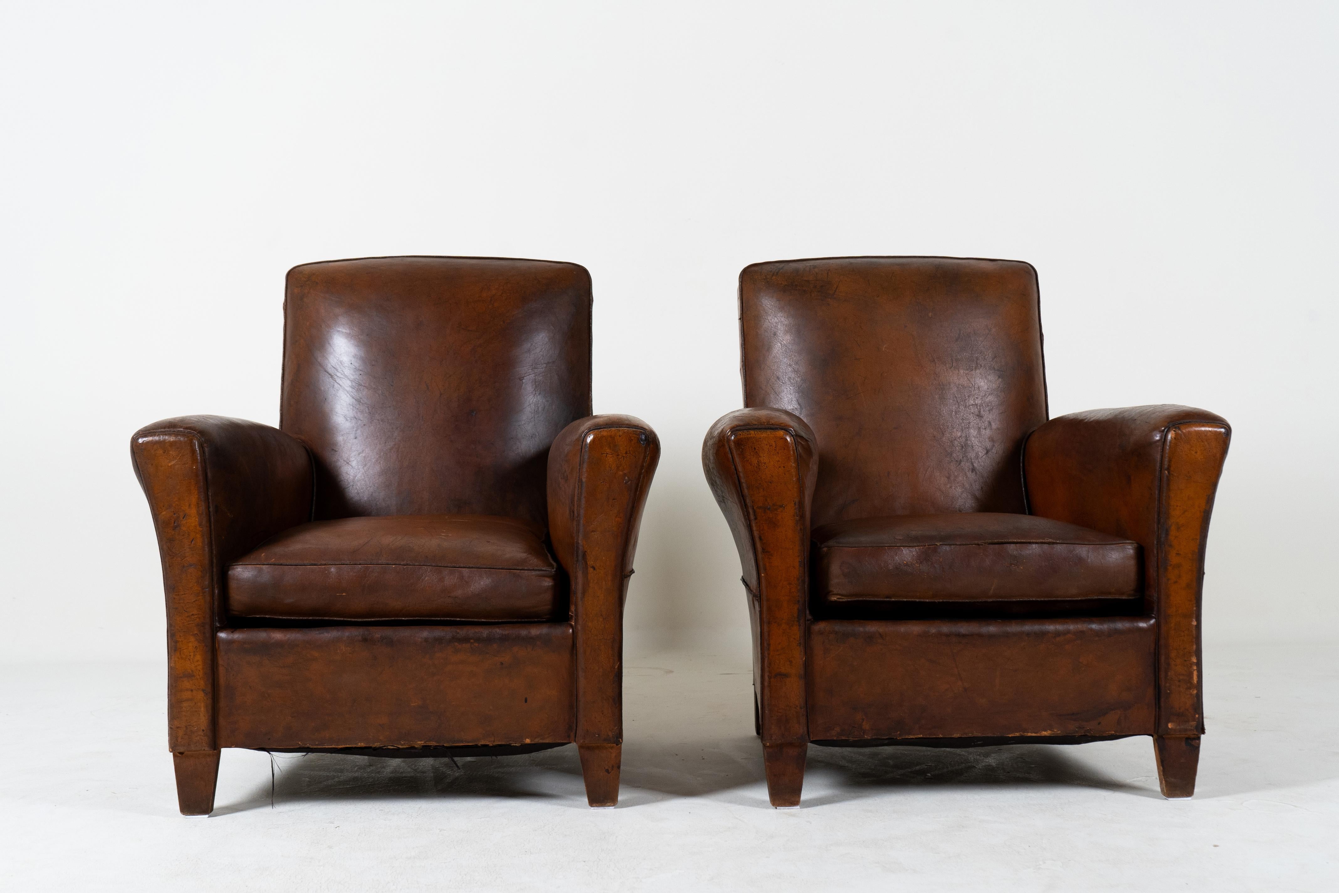 Ces fauteuils club en cuir français aux proportions gracieuses ont  Les lignes classiques de l'Art déco avec des accoudoirs légèrement arqués vers l'extérieur et des dossiers inclinés.   Les chaises sont confortables et parfaitement dimensionnées