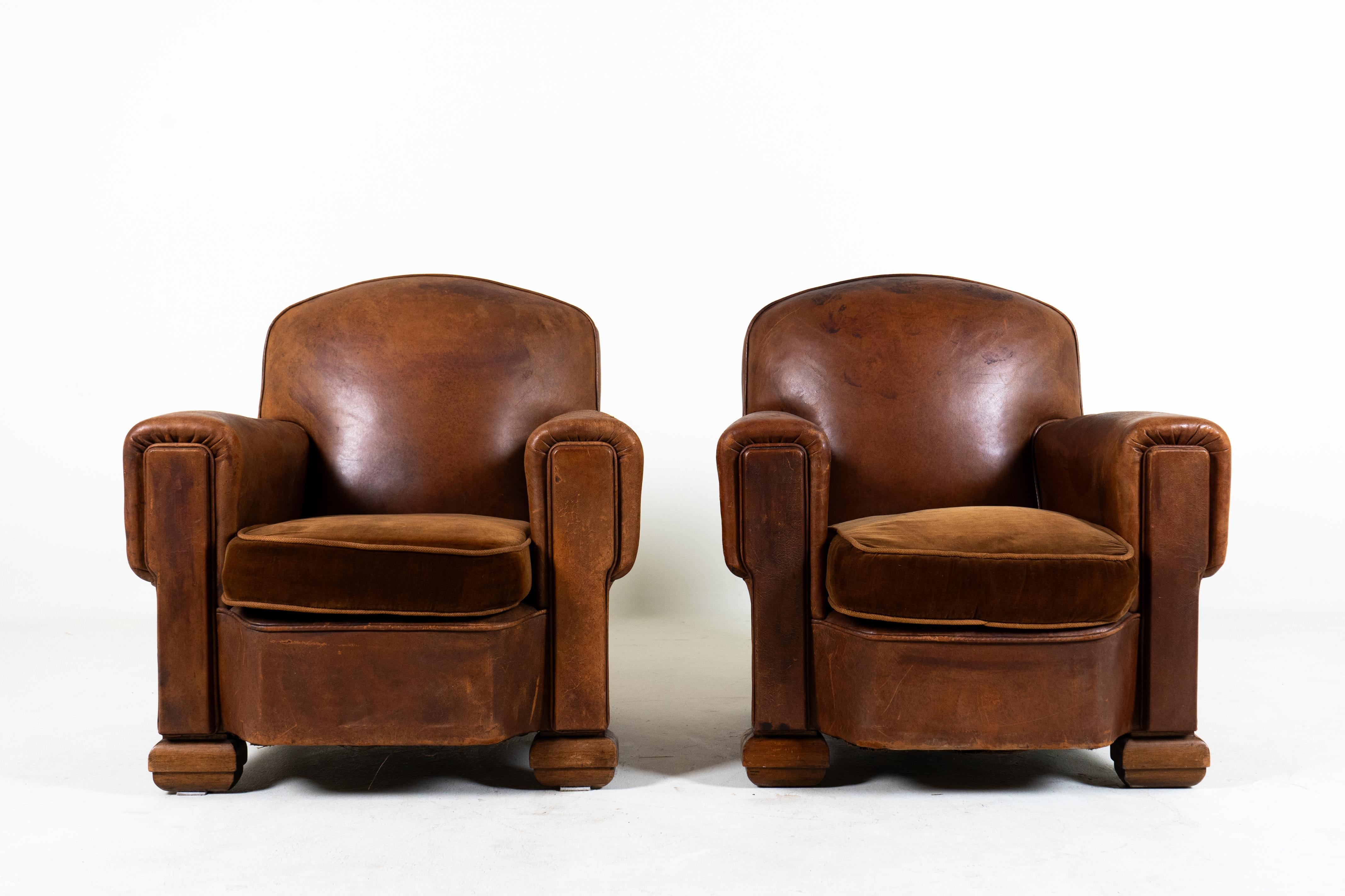 This pair of vintage French Art Deco club chairs date to the end of the era. With a design reaching back to the Art Deco period of the 1920s-1940s, these chairs represent the simplified and streamlined terminus of an era of Parisian elegance and
