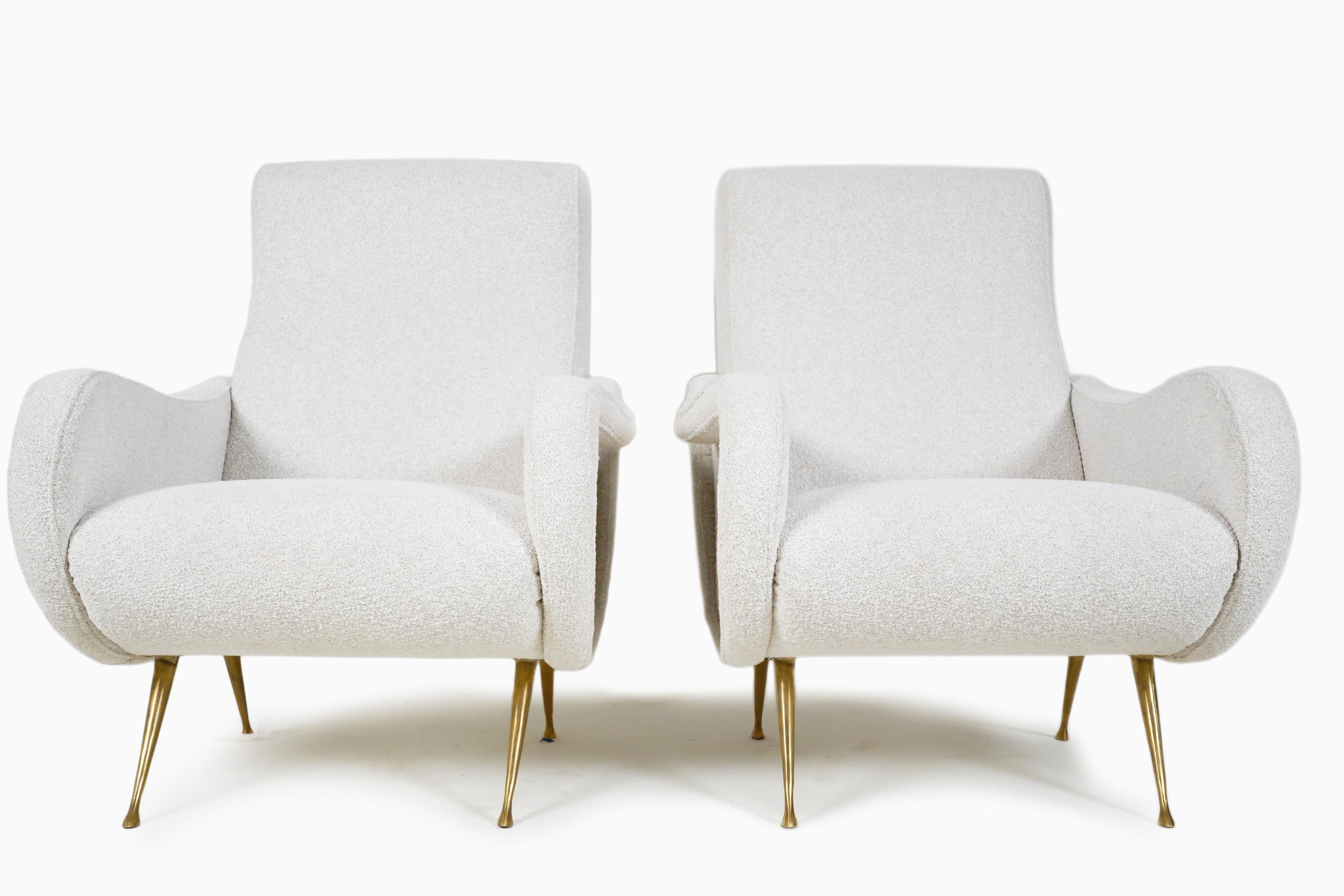 A Classic pair of Italian midcentury lounge chairs in the style of Marco Zanuso's 'Lady Chairs'. The chairs are set upon boldly splayed and tapered solid brass legs. The overall form is sensuous and organic and chairs are a visual treat, as well as