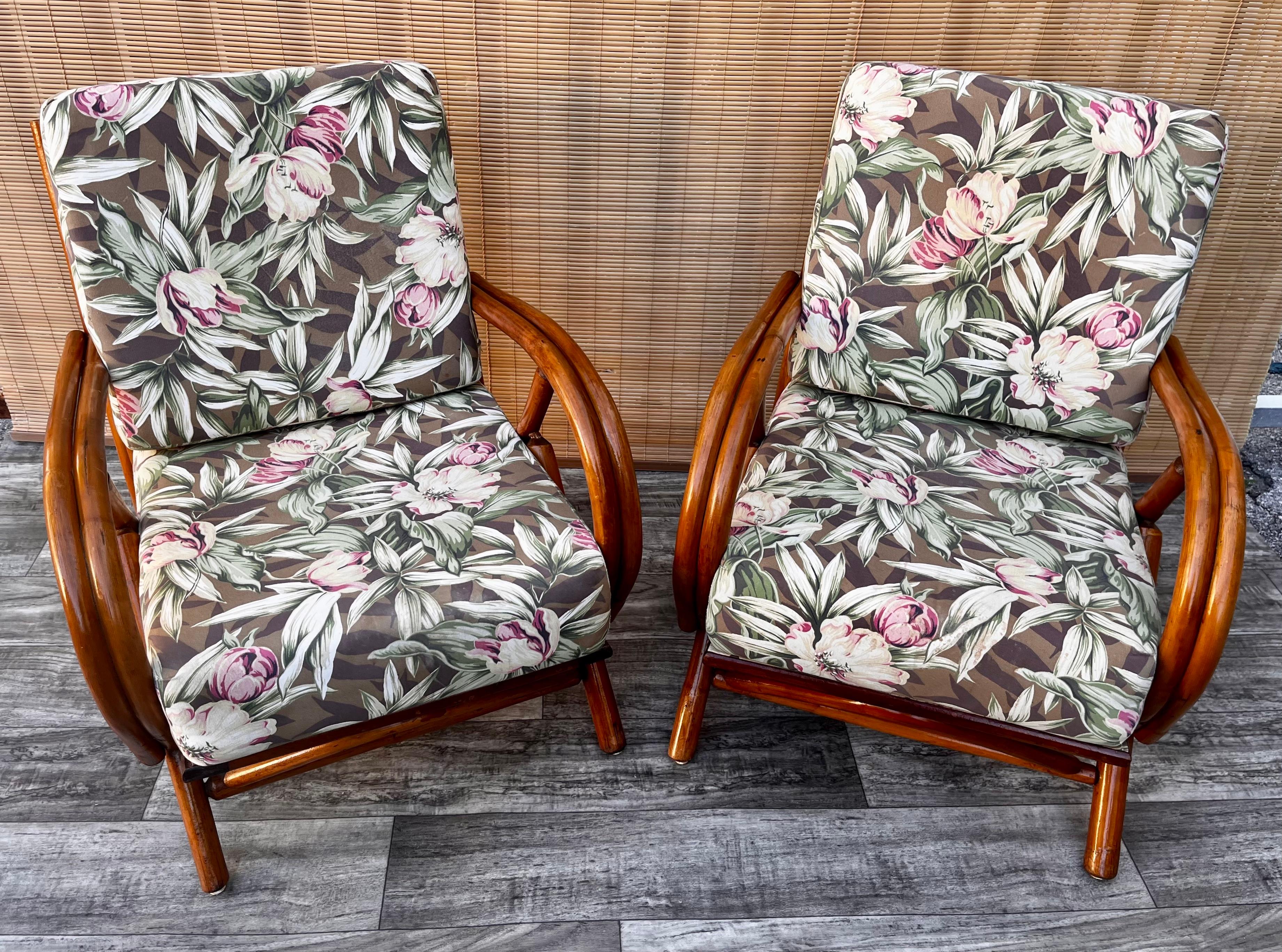 A pair of Vintage Mid-Century Modern Rattan lounge chairs, circa 1960s
Feature a rattan frame and bent rattan armrests with removable seating and backrest cushions, upholstered in floral motive fabric.
In good sound and cosmetic condition with