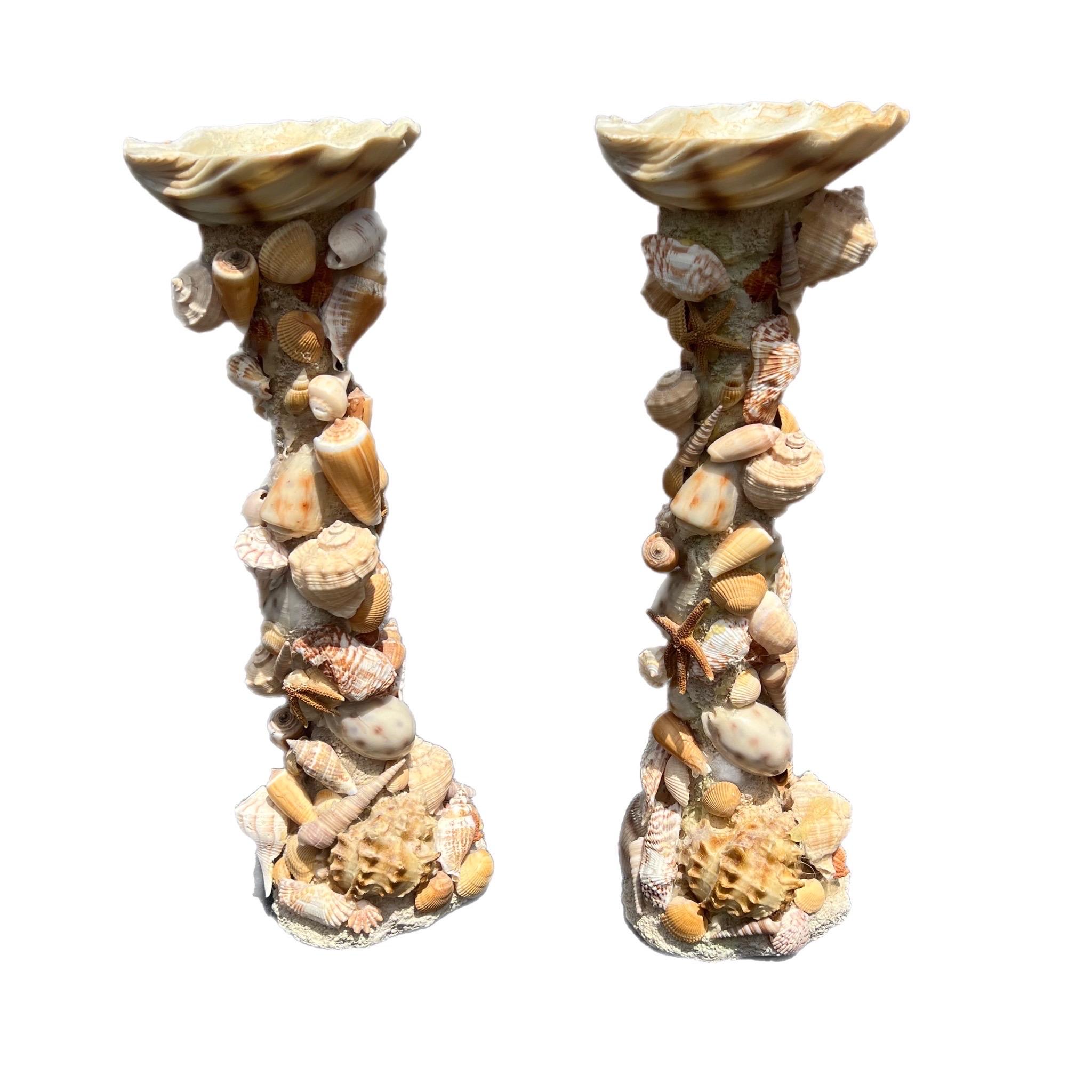 A large pair of shell encrusted pedestal candle holders. Made of resin, grout, and shells. handcrafted circa 1970s-1980s.