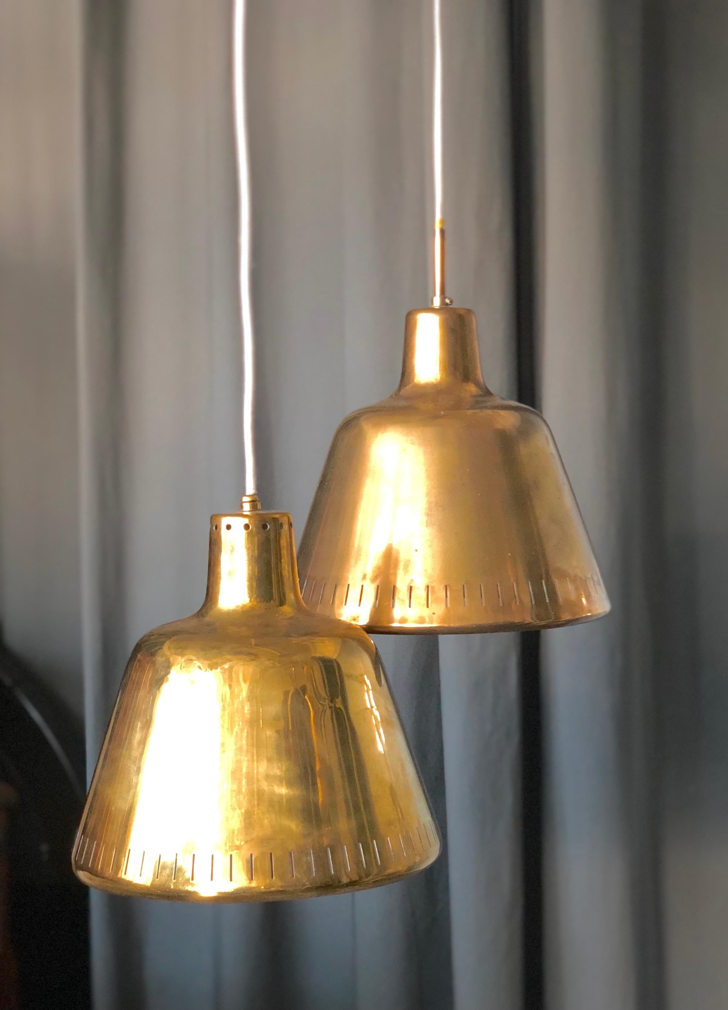 A pair of vintage pendants, probably Sweden, Circa 1940-50th. Design attributed to Harald Notini. Polished brass with single E26- type socket. The brass shades diameter 11