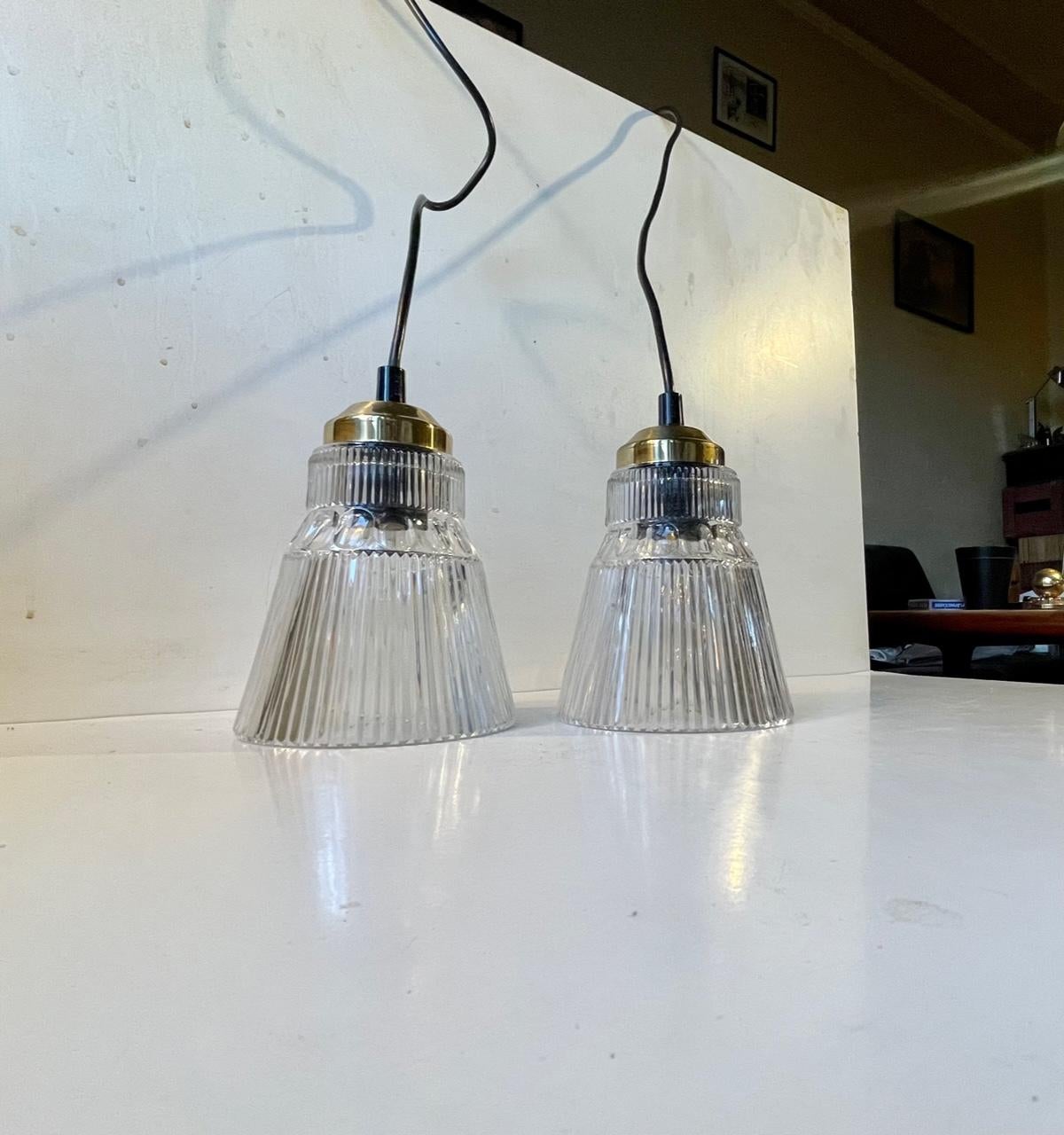 Stylish pendant lamps that resembles some of Hans Agne Jakobsson´s designs. Made from pressed partially fluted grey-tinted glass and set in brass tops. Made by an unknown Scandinavian maker circa 1980-90. Fitted with E27 socket, light bulbs, 2