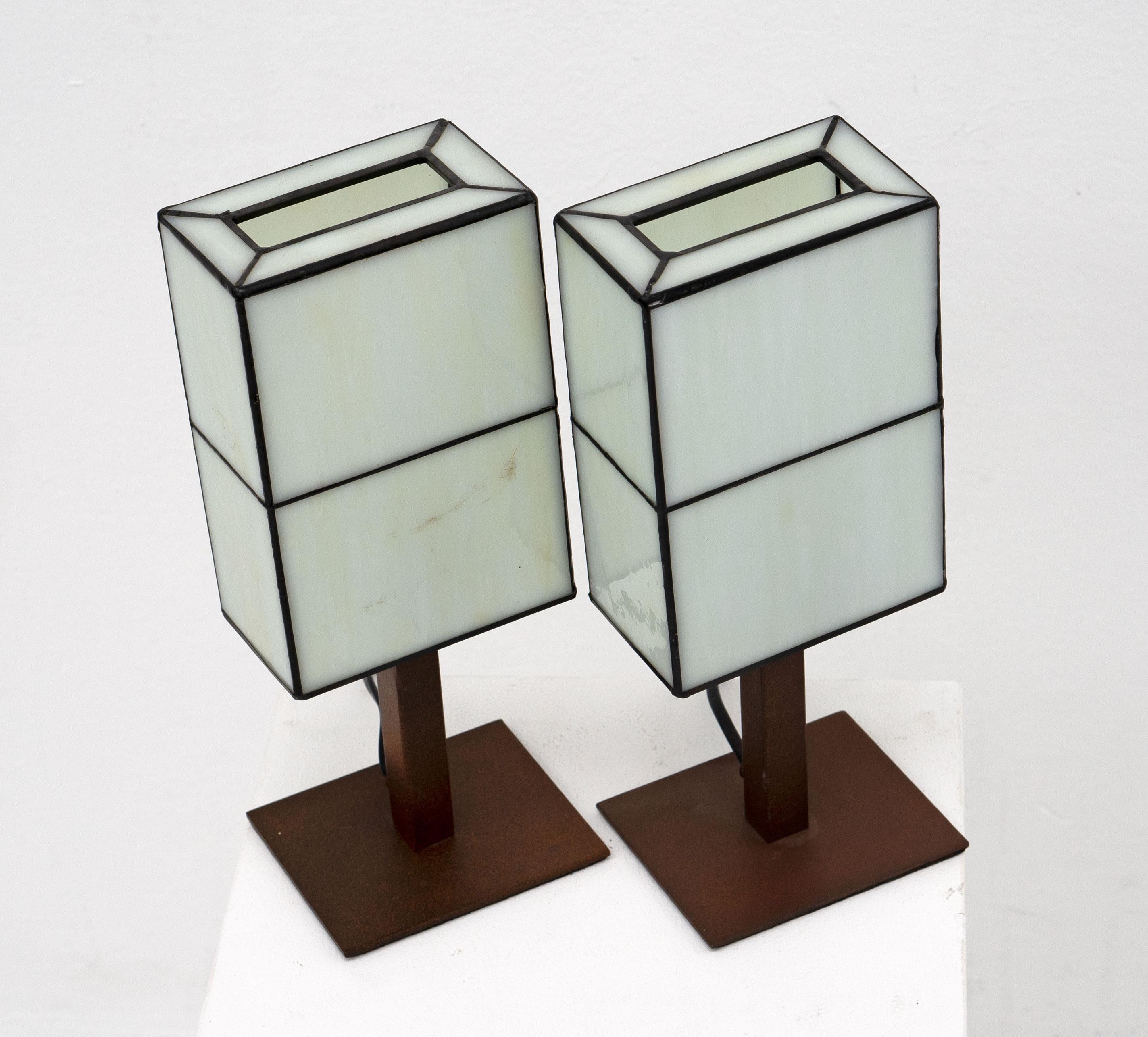 A great pair of small stained glass table lamps manufactured in Spain in the late 20th Century. The lamps have stained glass shades and corten steel bases.

Price is for the pair. 

Dimensions (cm, approx):
Height: 30
Width: 12
Depth: 10