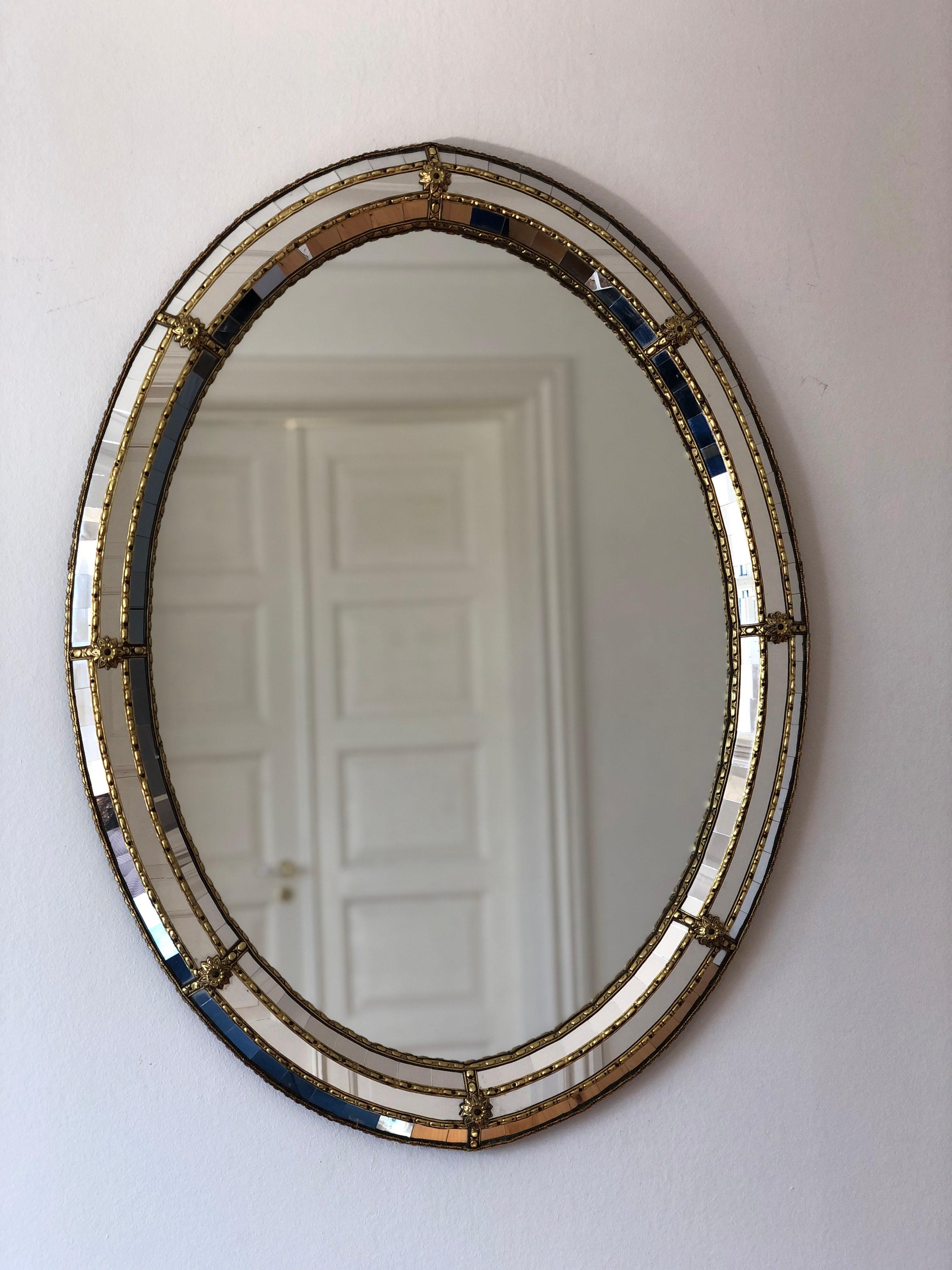 A pair of vintage Venetian oval mirrors in Spanish style, dating back to the 1990s.
The frame is beautifully hand-crafted and decorated with small crystals on the outer and inner edges, with larger crystals running along the center. The elegant