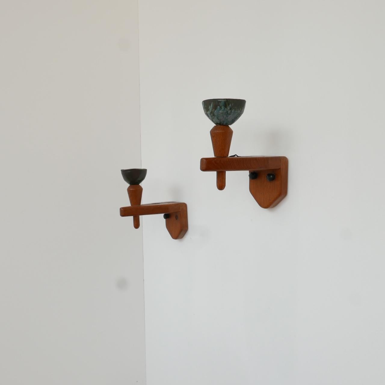 A pair of wall lights by French designers Guillerme et Chambron.

Oak with original ceramics.

The ceramics are the same finish, one is more triangular the other is more square.

Functional and stylish.

Dimensions: 10 W x 23 H x 21 H in
