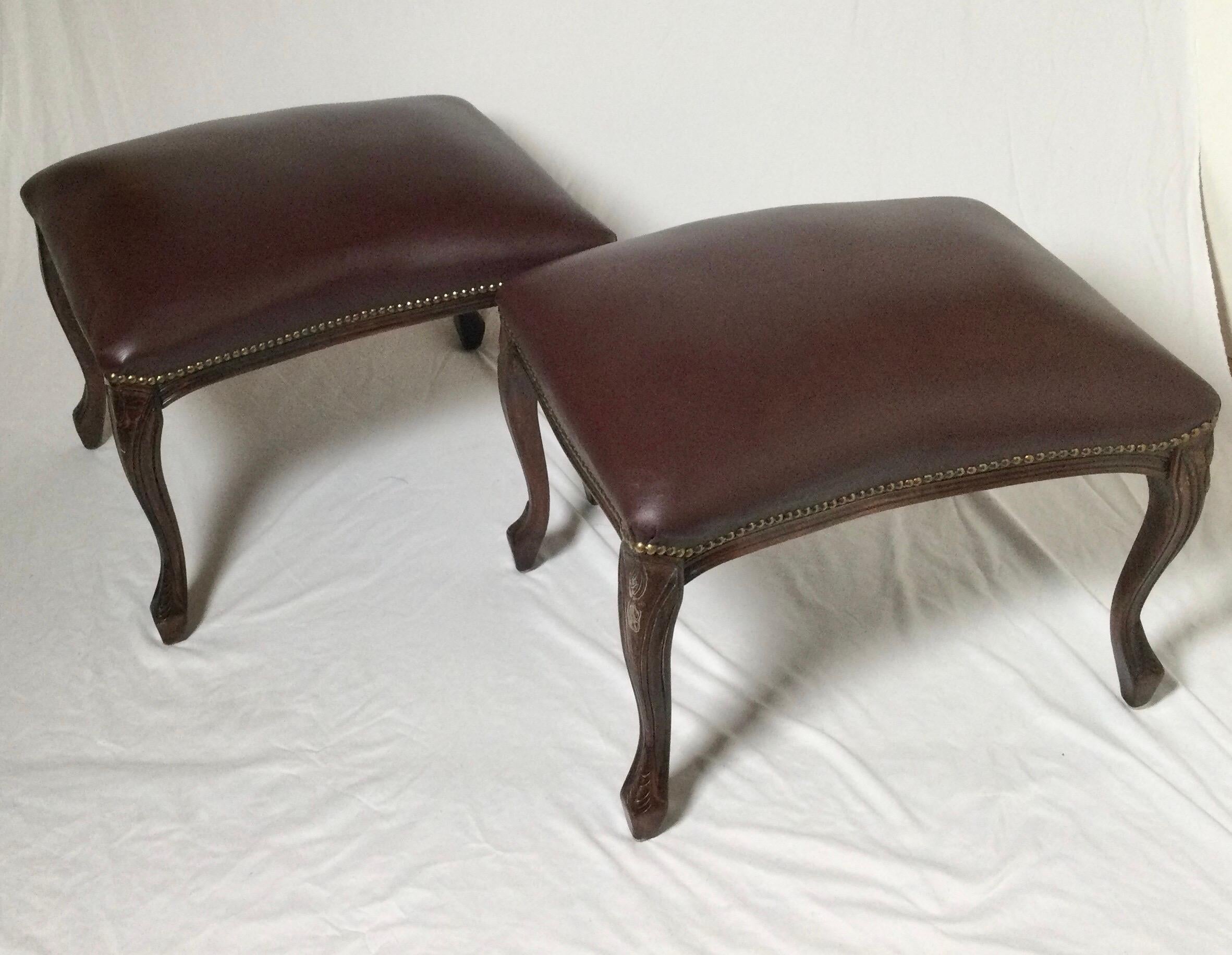 A pair of brown leather and dark walnut curved benches. The carve wood bases with tabboco brown leather tops with antiqued nailhead trim. A prefect pair.