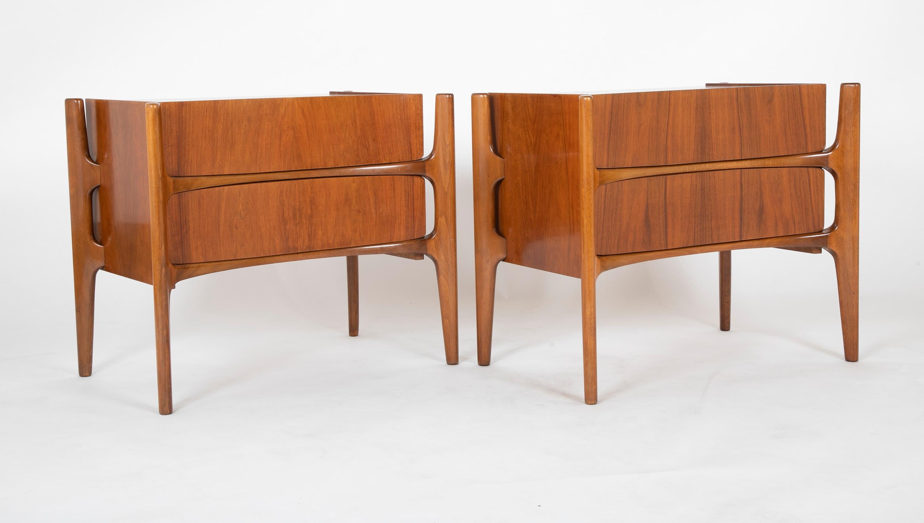 A pair of two drawer walnut cabinets with very modern lines. Designed by Edmund Spence. Both retain marking on back 