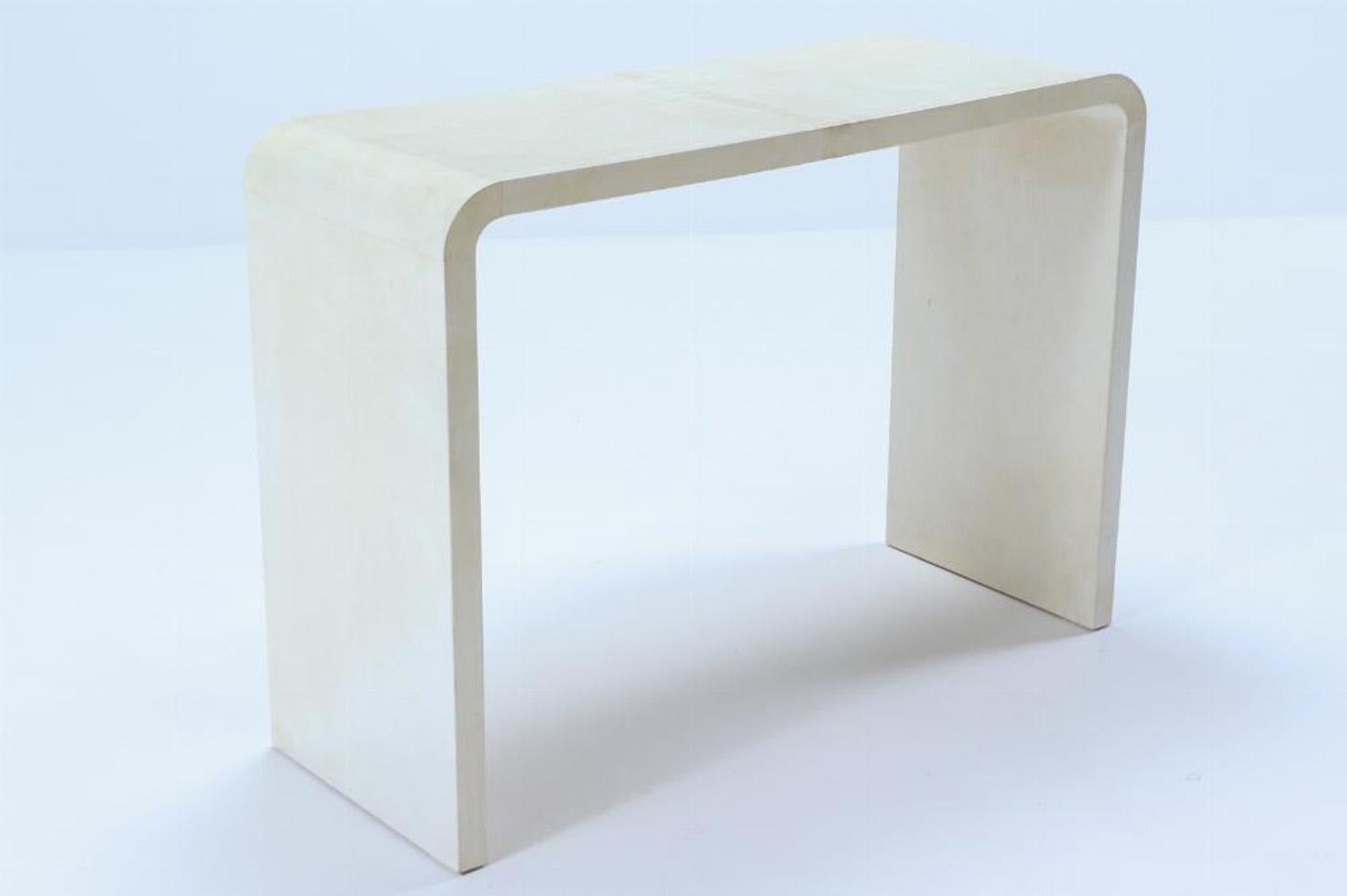 A pair of parchment covered waterfall console tables in the manner of Jean-Michel Frank (1895-1941). Contemporary. The inverted U-form will add a simple and understated elegance to your interiors. Perfect addition to flank an entryway or behind