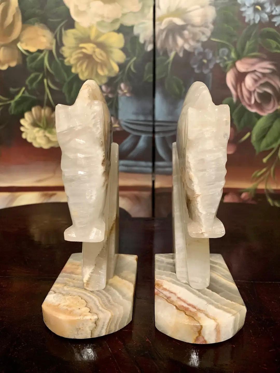 A stunning pair of exquisitely hand-carved figurehead bookends sculpted from a singular piece of authentic Mexican white agate, beautifully grained and wonderfully preserved. 

Prized for centuries dating back to the ancient Greek and Egyptian