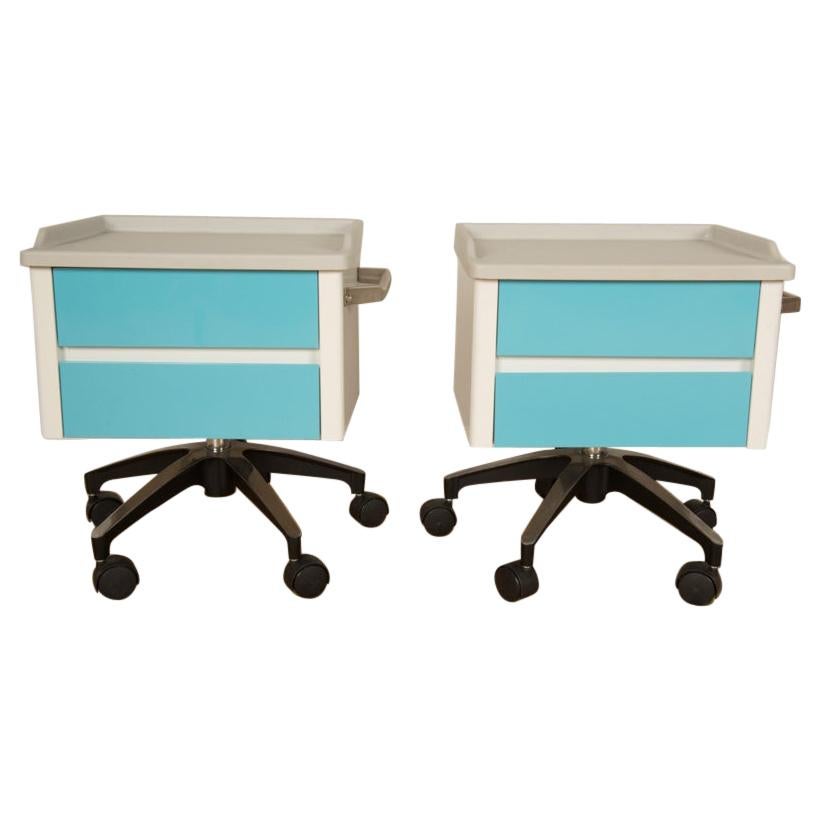 Paire de meubles de rangement d'appoint à deux tiroirs blancs et bleus sur base à roulettes, vers les années 1970.