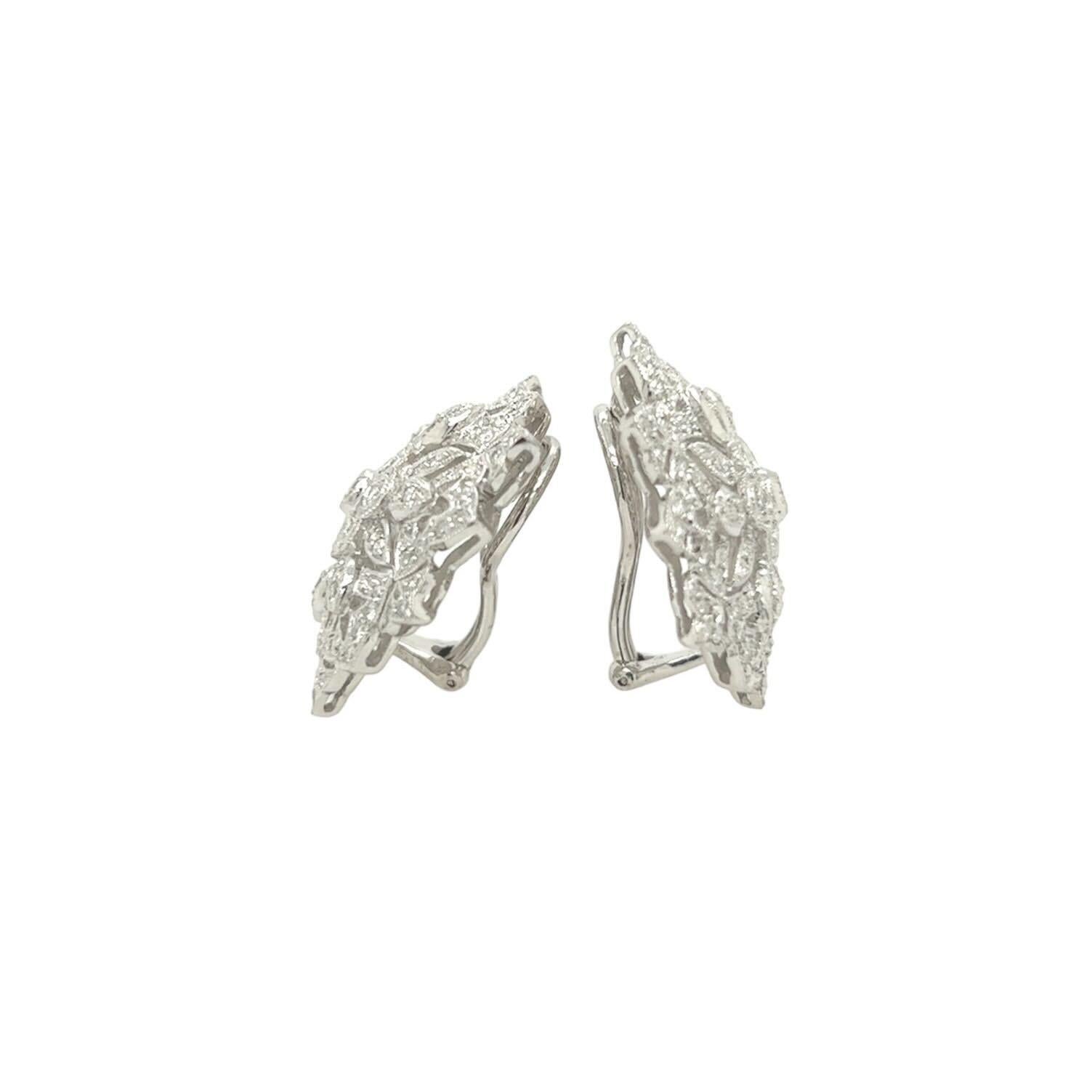 A pair of 18 karat white gold and diamond earclips.  Each earclip designed as openwork floral motif set all over with approximately one hundred three  round brilliant cut diamonds within milgrain edges.  Total diamond weight approximately 4.60