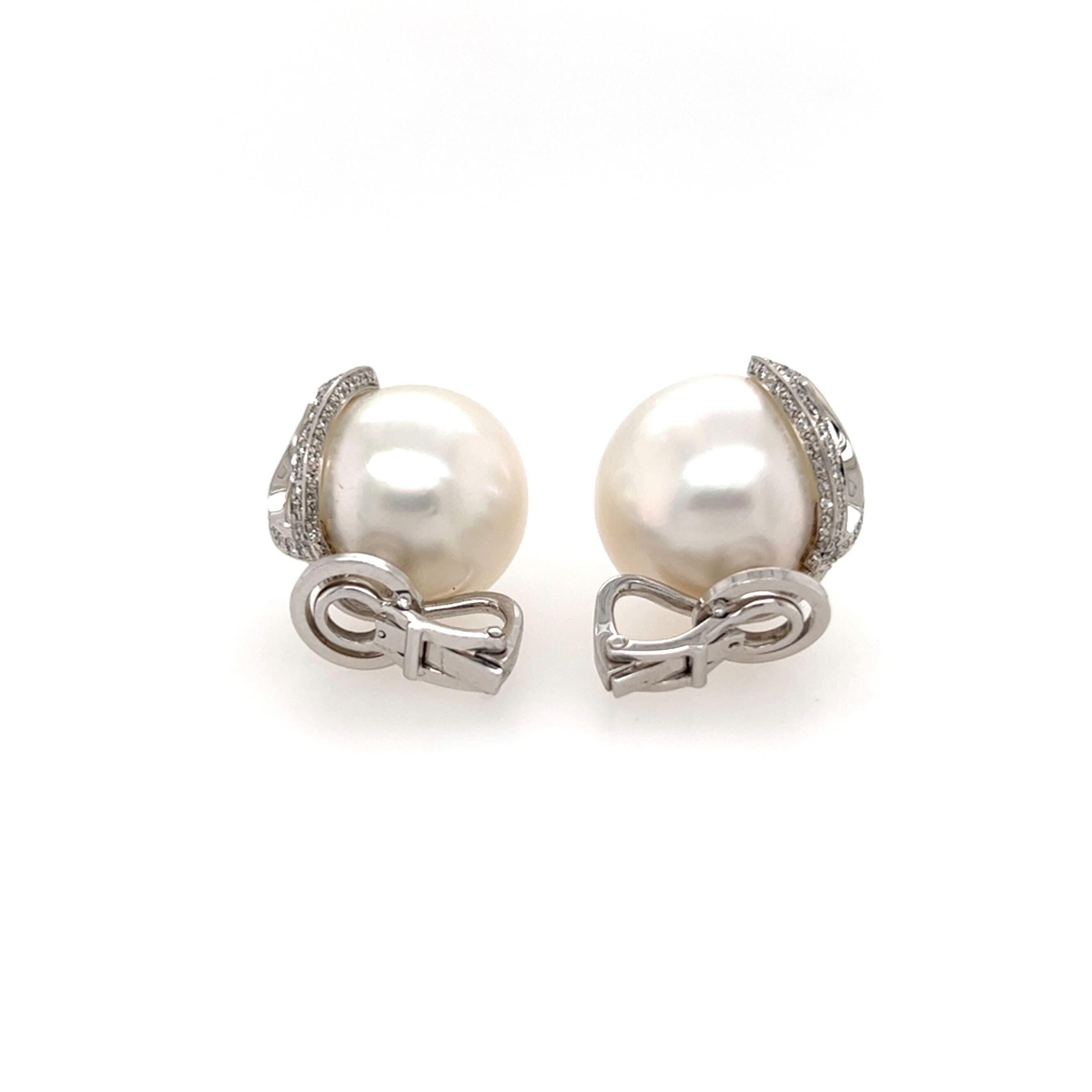 A pair of 14 karat white gold, pearl and diamond earclips.  Each earclip fashioned as a South Sea pearl measuring approximately 17.3 mm. applied with an open oval set on the top and outer edges with approximately fifty (50) brilliant cut diamonds. 