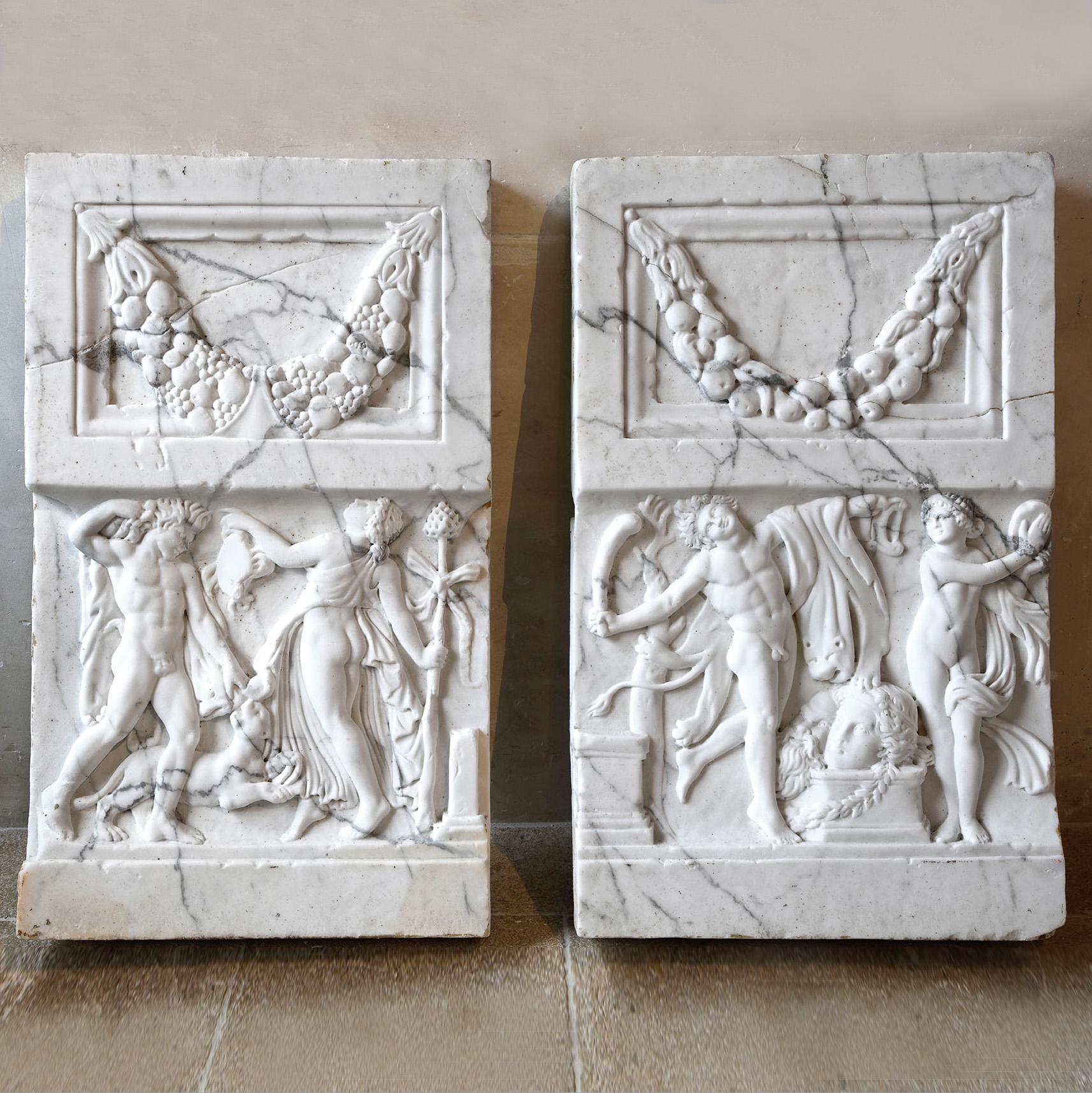 A pair of white marble relief frieze panels, circa 1920, each with a flower and fruit garland above a panel decorated with male and female figures in a neoclassical manner.

h 96 x w 57 x d 7.5 cm