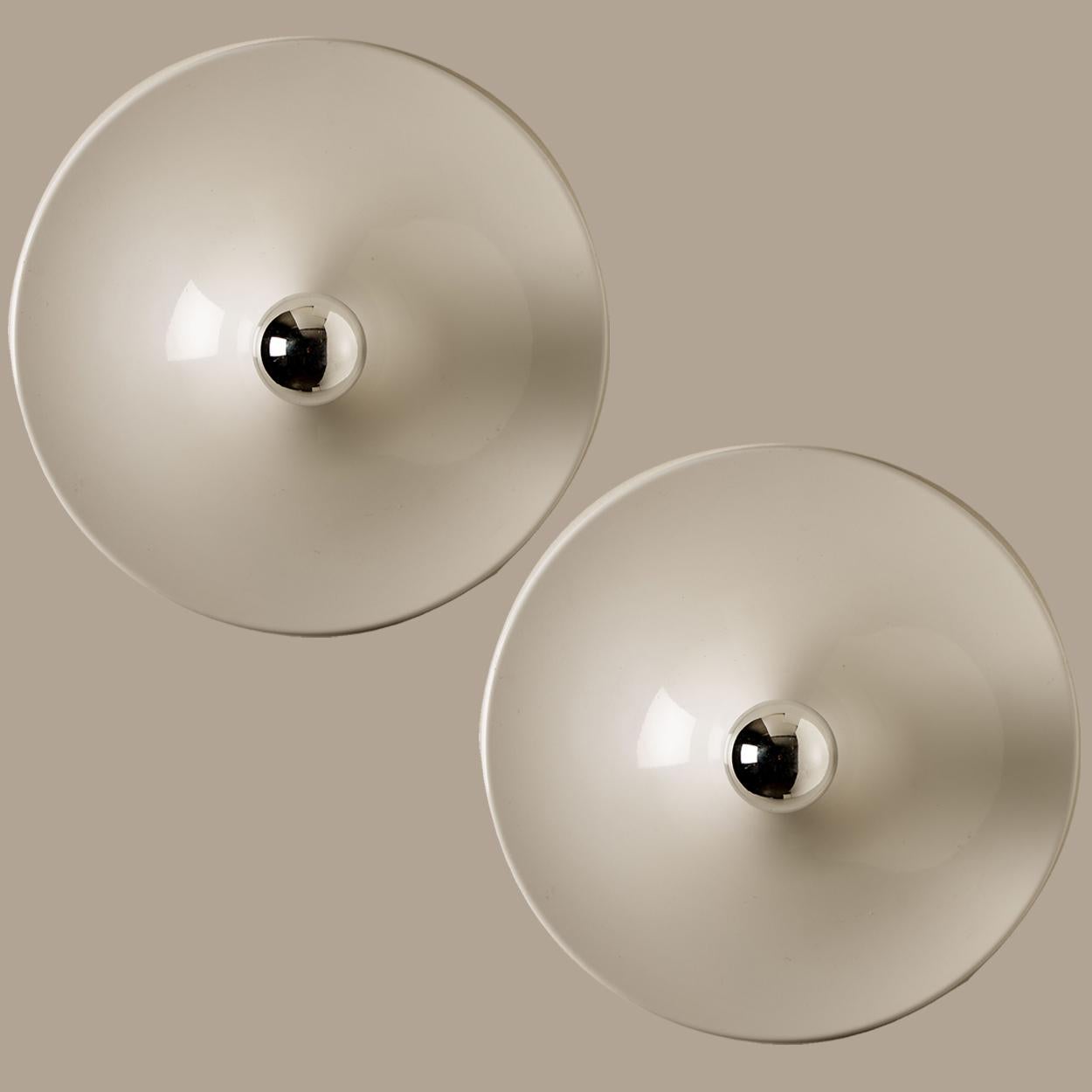A gorgeous set of two disc wall lights, designed by Gianluigi Gorgoni. Manufactured by the Italian lighting company, Stilnovo in 1970's. The lights are made of a white coated metal. They can be used as wall lights but also look great as a ceiling
