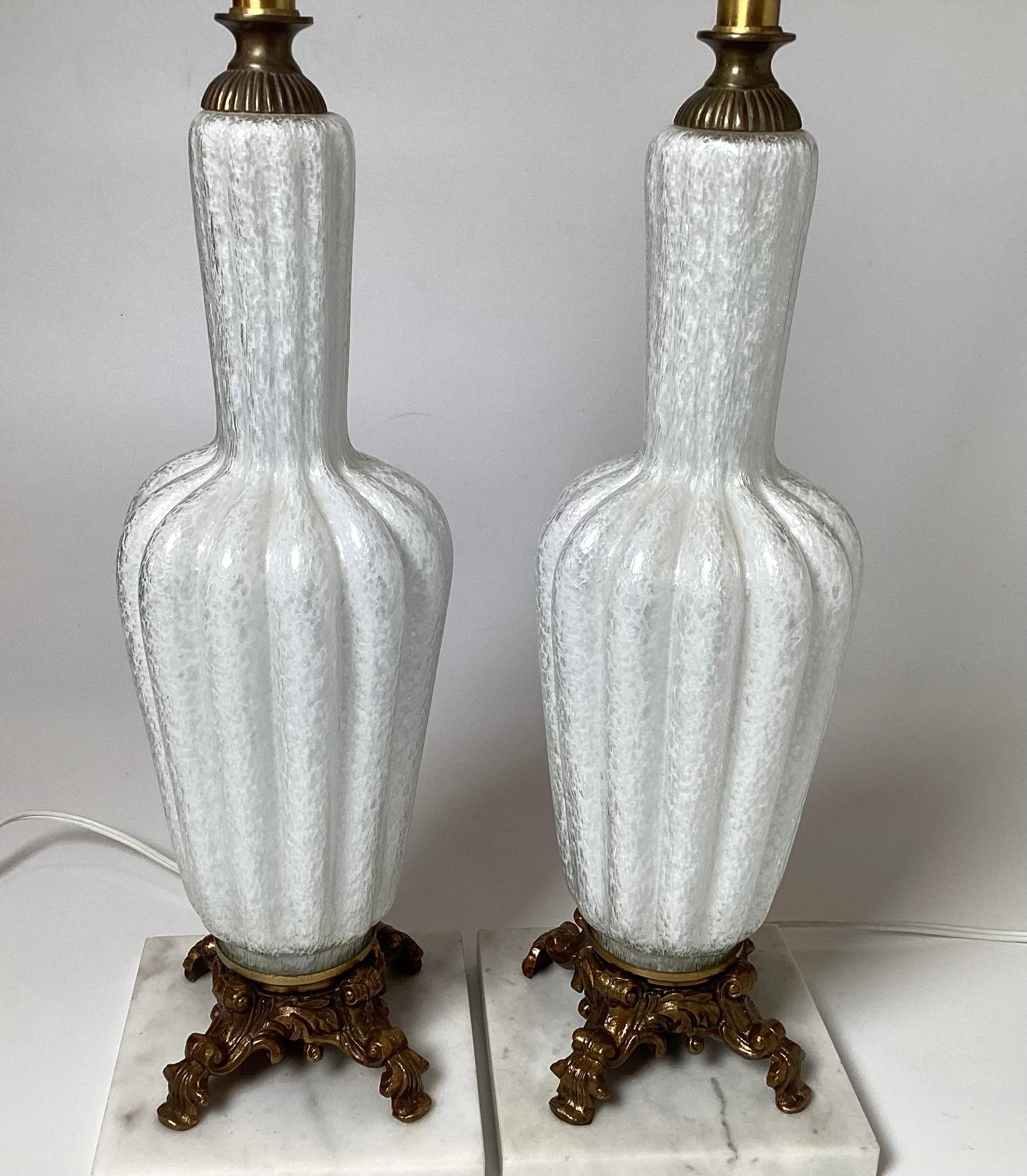 Ein Paar gerippte Flaschenform Murano Italien Tischlampen.  Das weiße und klare Glas mit Messinggussfüßen ruht auf einem quadratischen Sockel aus Carrera-Marmor. Kürzlich neu verkabelt.  20,5 Zoll groß.  