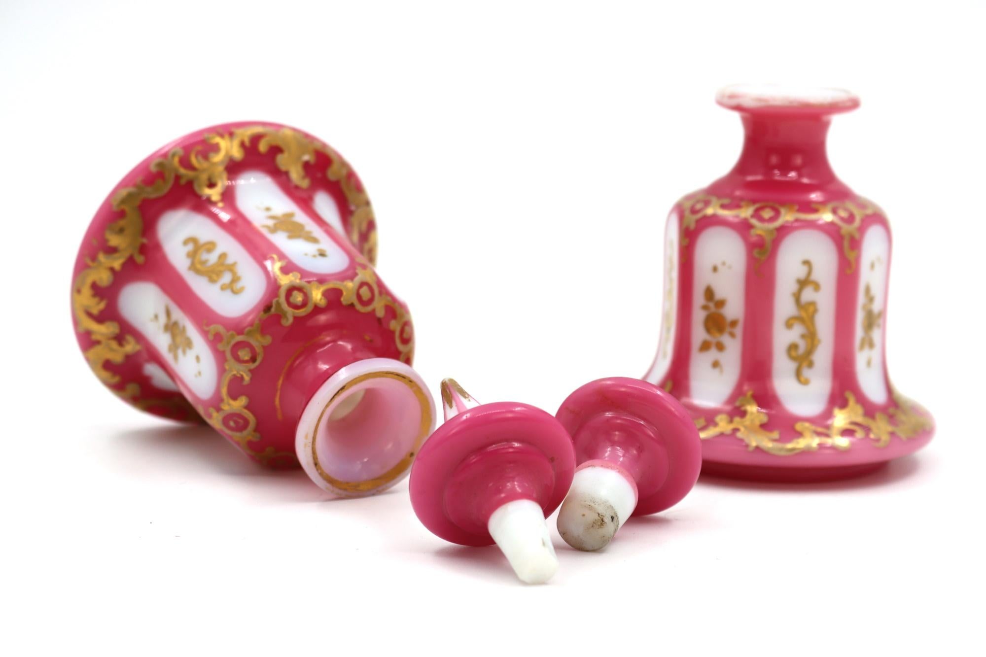 A pair of white opaline and pink overlay perfume bottles, gold enamelled, 19th century, 1840 - 1860.
Measures: H: 15 cm, D: 9 cm.