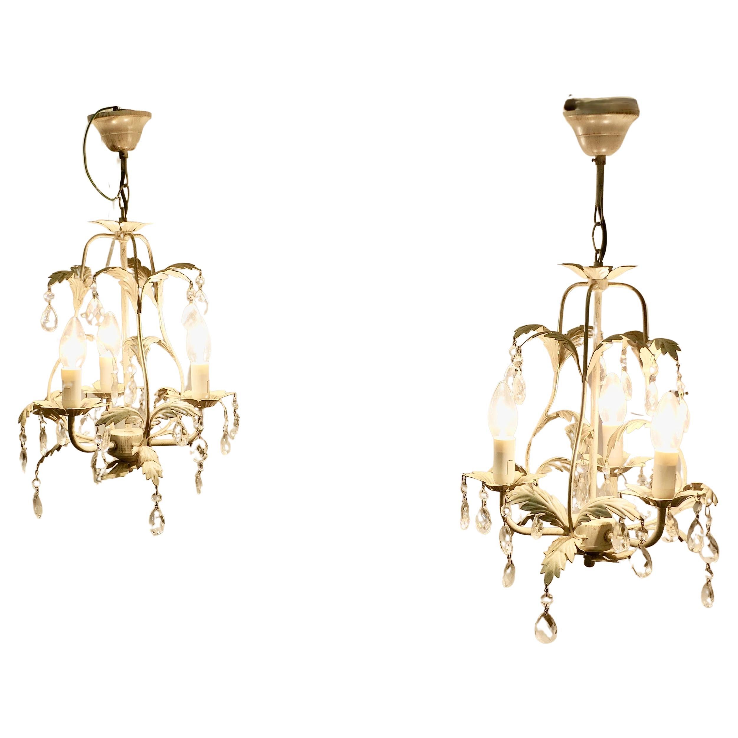 Coppia di lampadari da soffitto a cestello aperto in toleware bianco

Si tratta di una coppia di plafoniere circolari decorative, aperte al centro e decorate con foglie di toleware in bianco mela con splendidi lustri sfaccettati a forma di pera. 