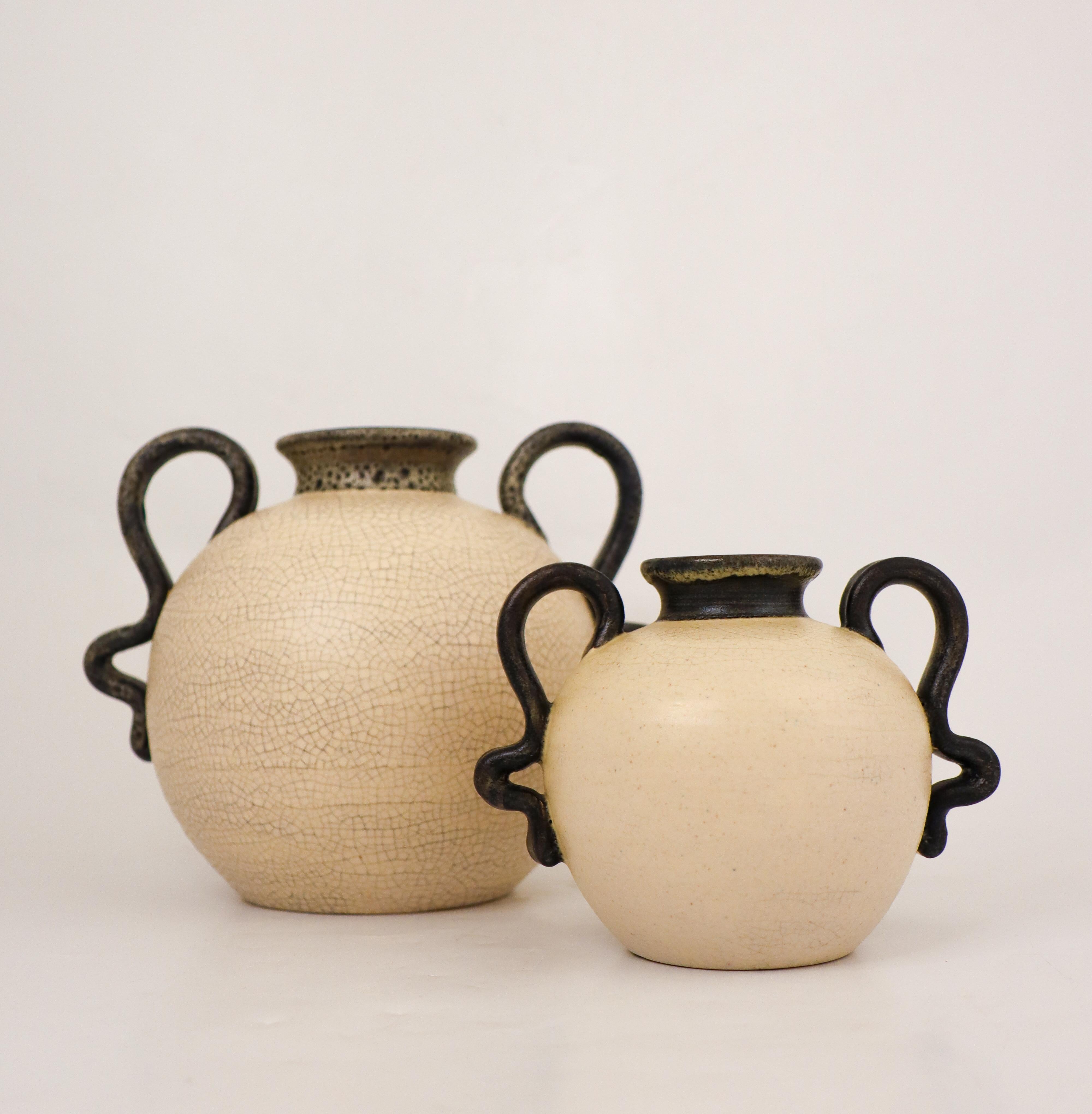 Une paire de jolis vases de couleur crème avec de jolies poignées, conçus par Eva Jancke-Björk chez Bo Fajans à Gefle dans les années 1940. La plus grande mesure 16,5 cm de haut et 20 cm de diamètre et la plus petite 11 cm de haut et 14,5 cm de