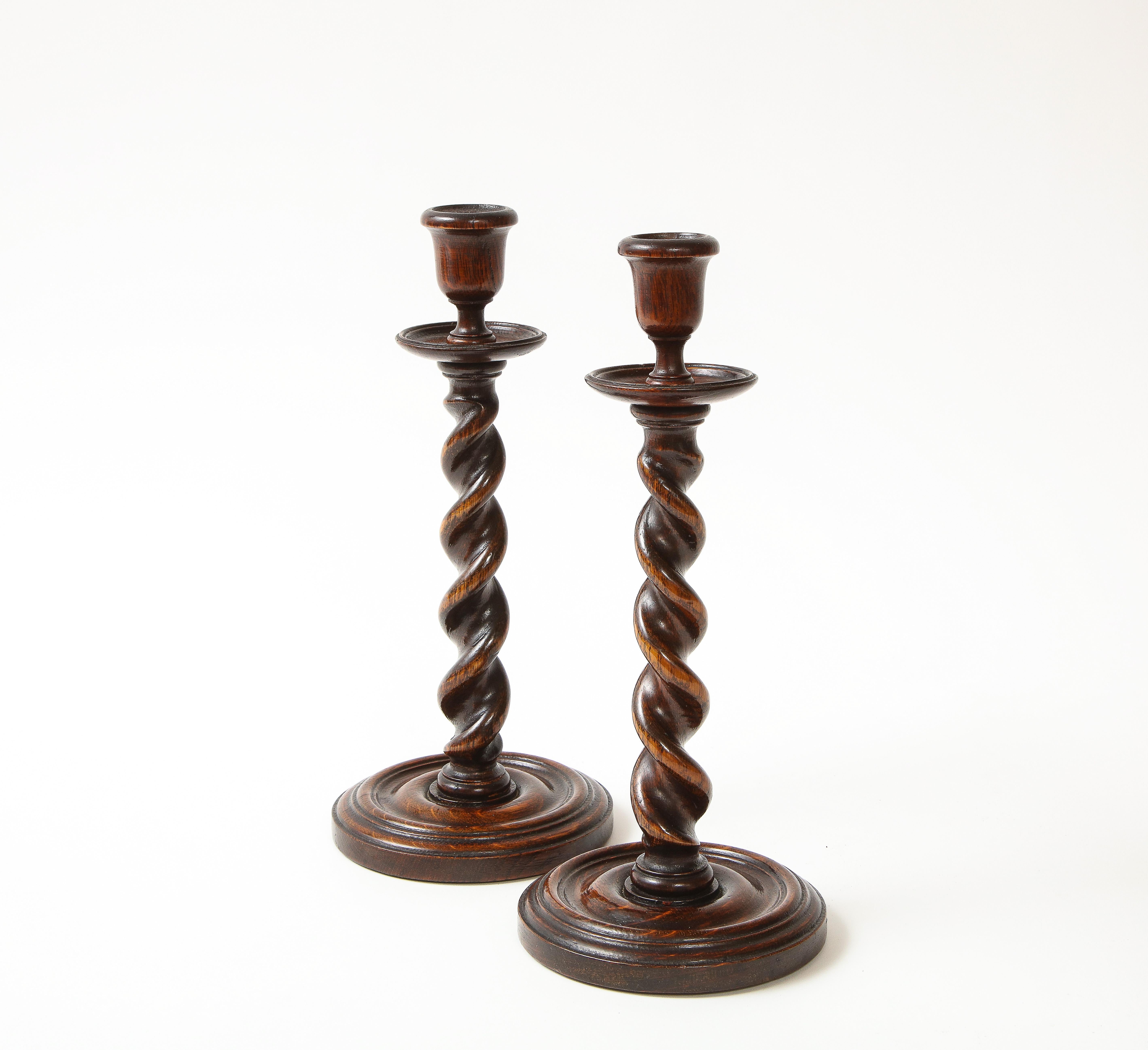 Carved of handsomely figured oak stained a rich deep brown; with spiral-fluted supports on turned round bases.