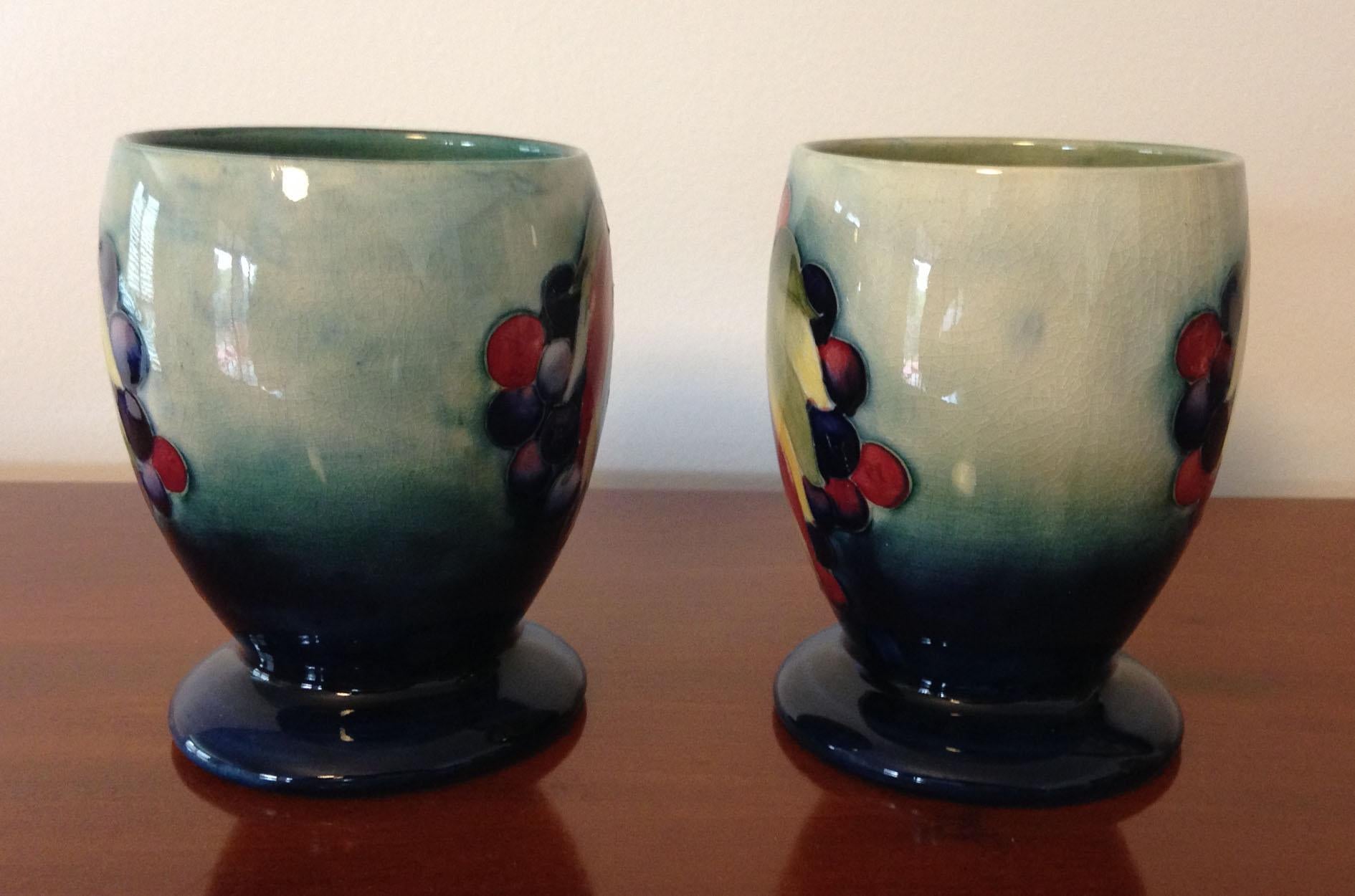 A rare pair of William Moorcroft designed leaf and berry pattern goblets with a pale blue/green background, circa 1930.

Fully signed to the base W. Moorcroft, with the factory stamp 'Made In England' and 'Potter to The Queen'.