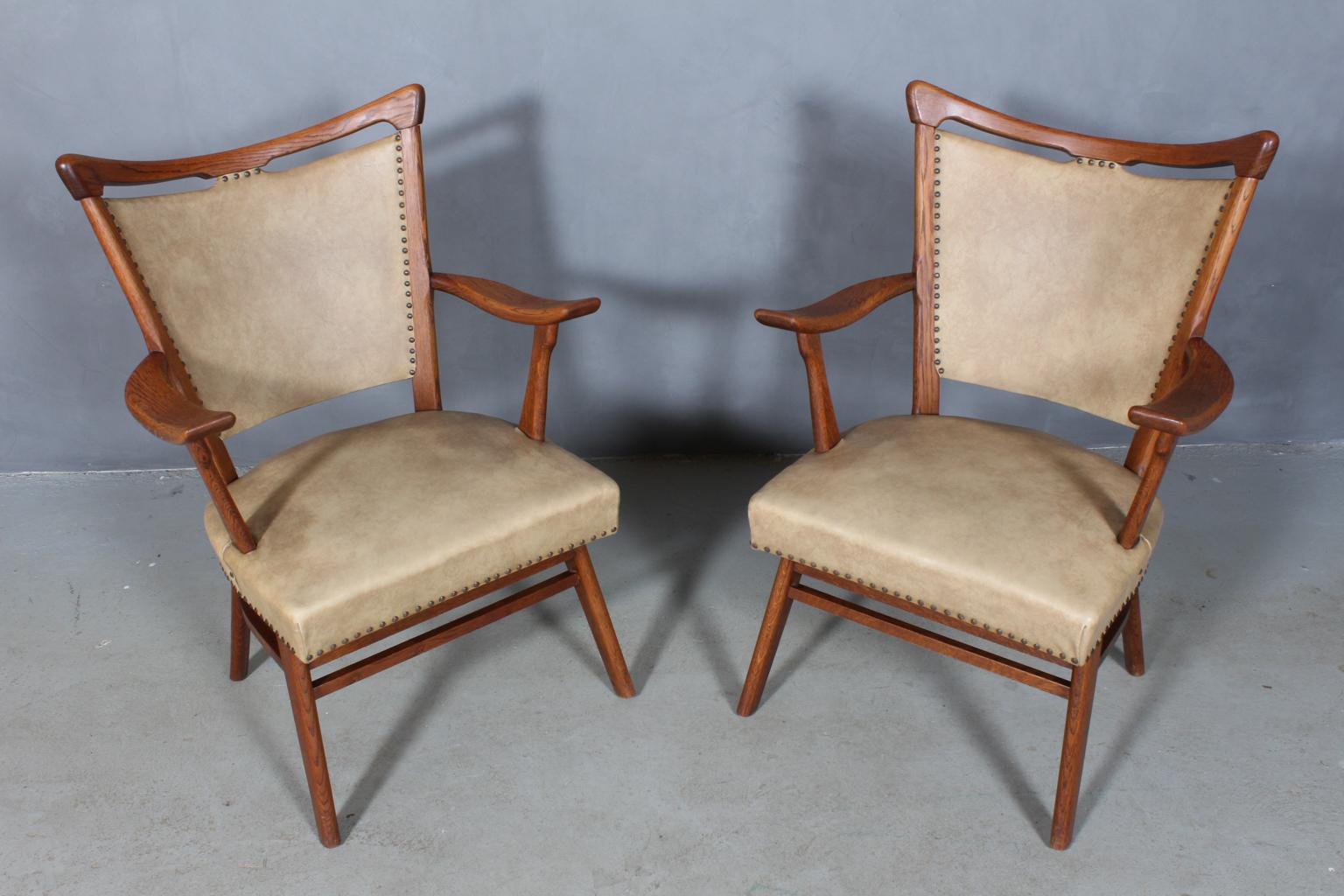 A pair of Windsor armchairs in solid oak.

Upholstered with skai.

Made in the 1950s in Scandinavia.

Great craftsmanship.