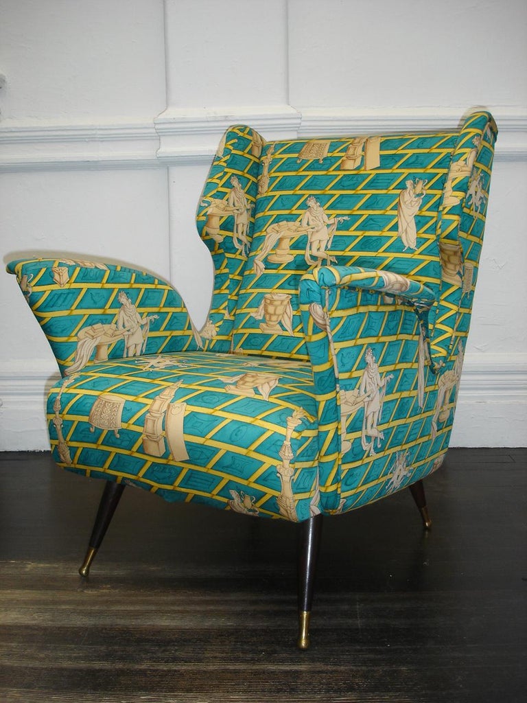 A pair of wing back chairs in the manner of Gio Ponti. These distinctive chairs are covered in Gio Ponti's 