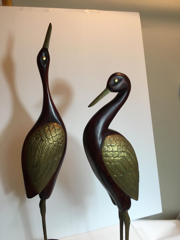 A pair of wood and brass cranes by Frederick Cooper.