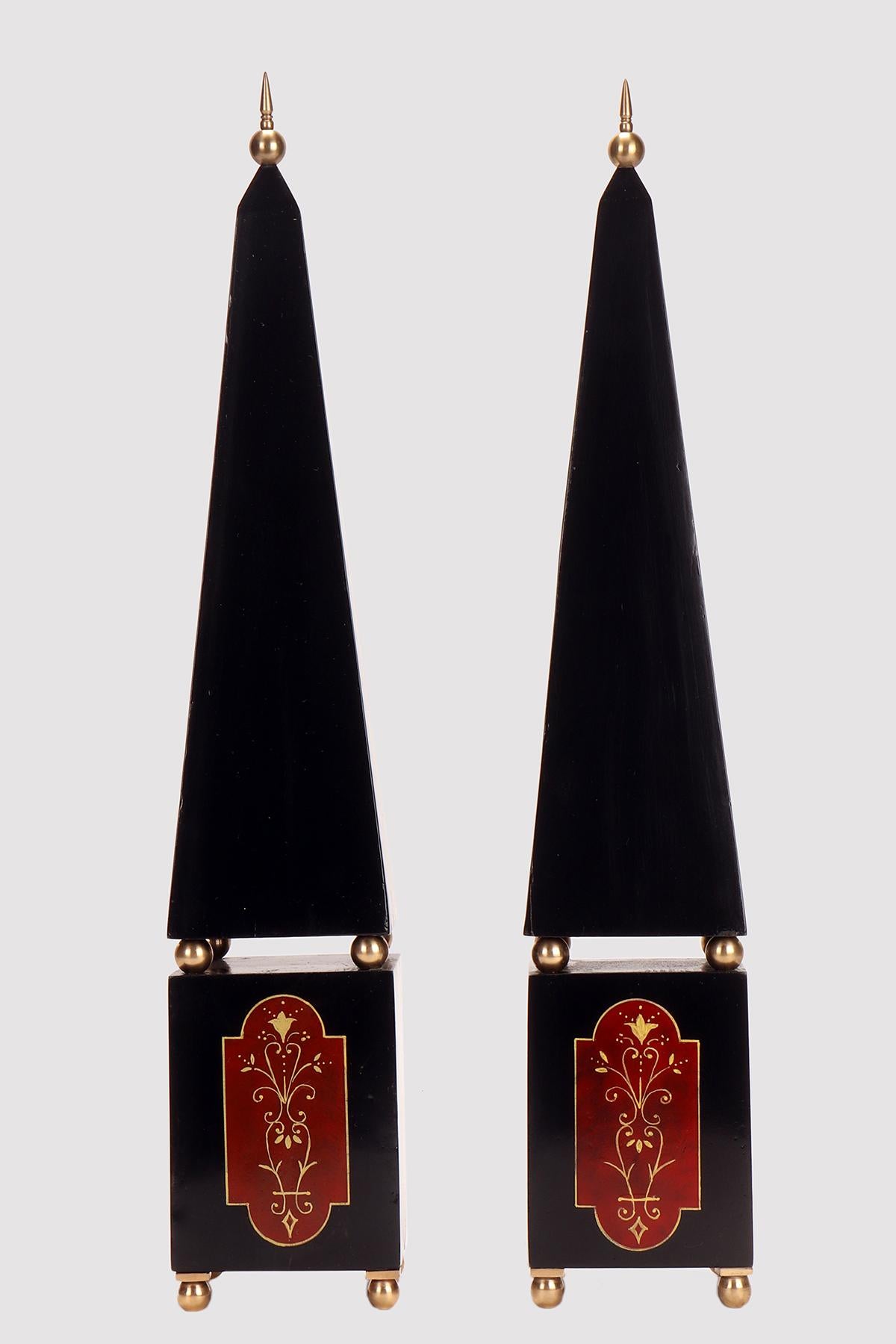 A pair of Grand tour obelisks, made out of lacquered wood emulating Black Belgian marble and gilt brass elements.  Four gilt brass spheres are the feet, than a parallelepiped base with painted emulating ‘Rosso Antico’  marble elements decorated with